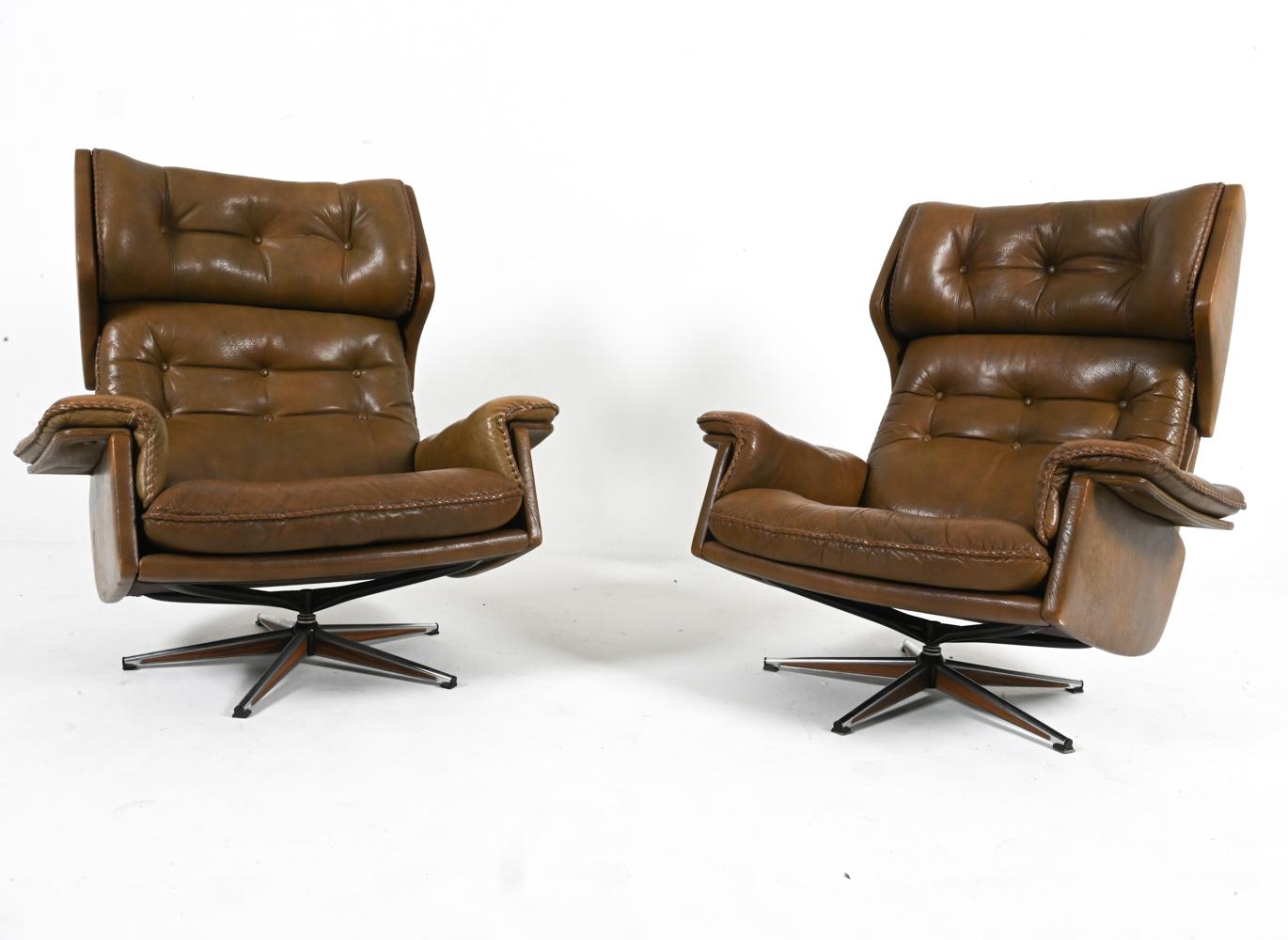 Immerse yourself in Scandinavian comfort and style with this exquisite pair of swivel armchairs by notable Swedish designer Arne Norell. Crafted from rich and supple buffalo leather, these chairs exude an aura of timeless elegance. The deep,