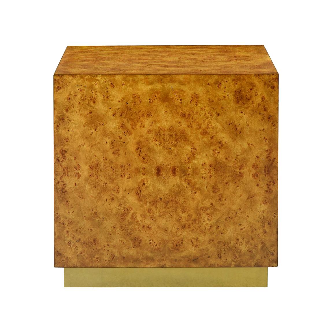 Conçue avec des lignes épurées et modernes, cette table cubique est enveloppée d'un luxueux placage de ronce de mappa, mettant en valeur ses riches tons dorés et son grain de bois complexe. La base est rehaussée d'un socle en laiton brillant,