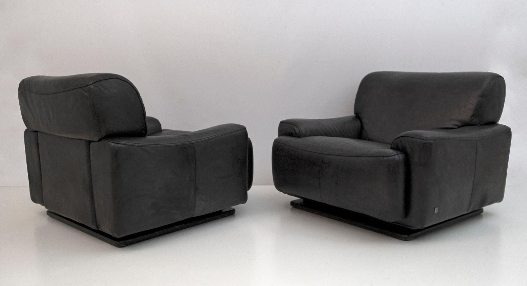 Paar Piumotto-Sessel, hergestellt von Busnelli, 1970er Jahre.
Polsterung aus echtem rauchgrauem Leder
Sockel aus schwarz lackiertem Holz.
