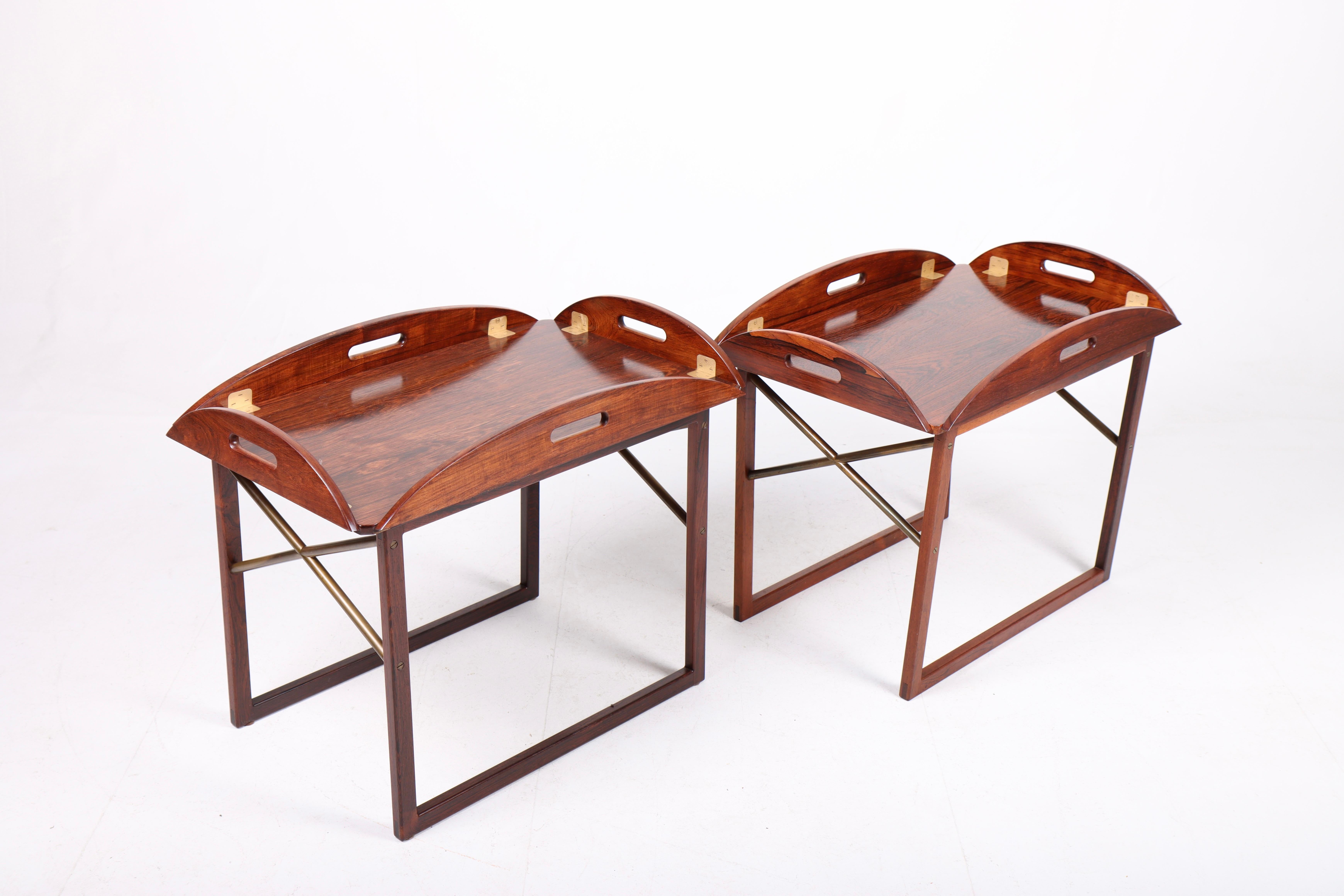 Pair of stunning end / tray tables in rosewood with brass hardware. Designed and made by Svend Langkilde of Denmark in the 1960s. Great original condition.