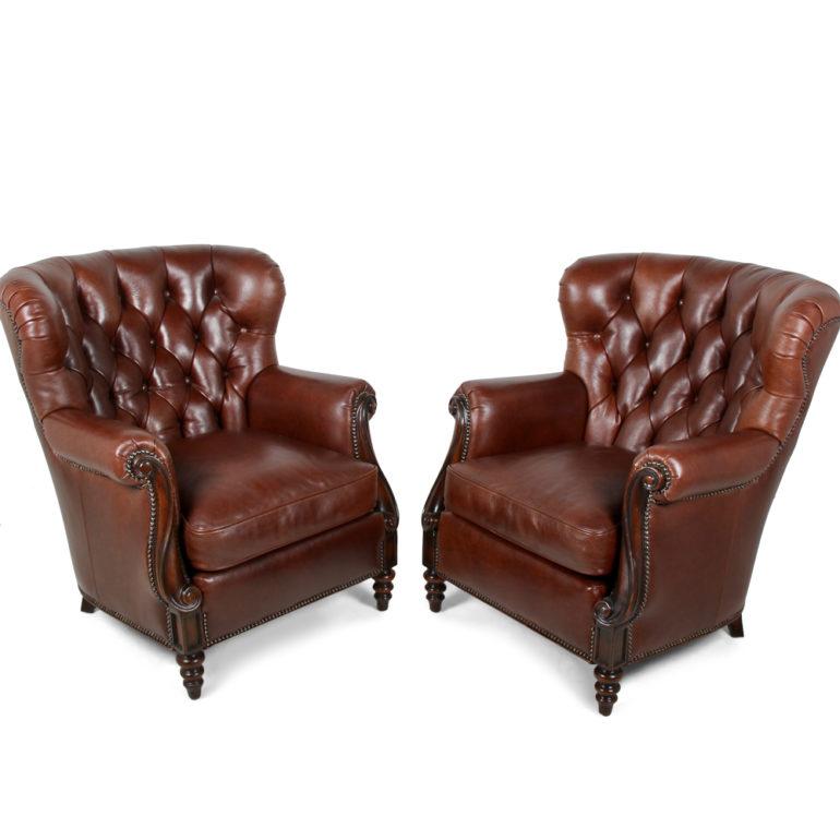 A pair of excellent quality button-tufted leather wing back armchairs with scroll-carved arms and metal stud finishing to the seams.

New condition by high-end maker Whitetmore Sherrill of North Carolina, circa 2010. 

Since 1946, Sherrill has