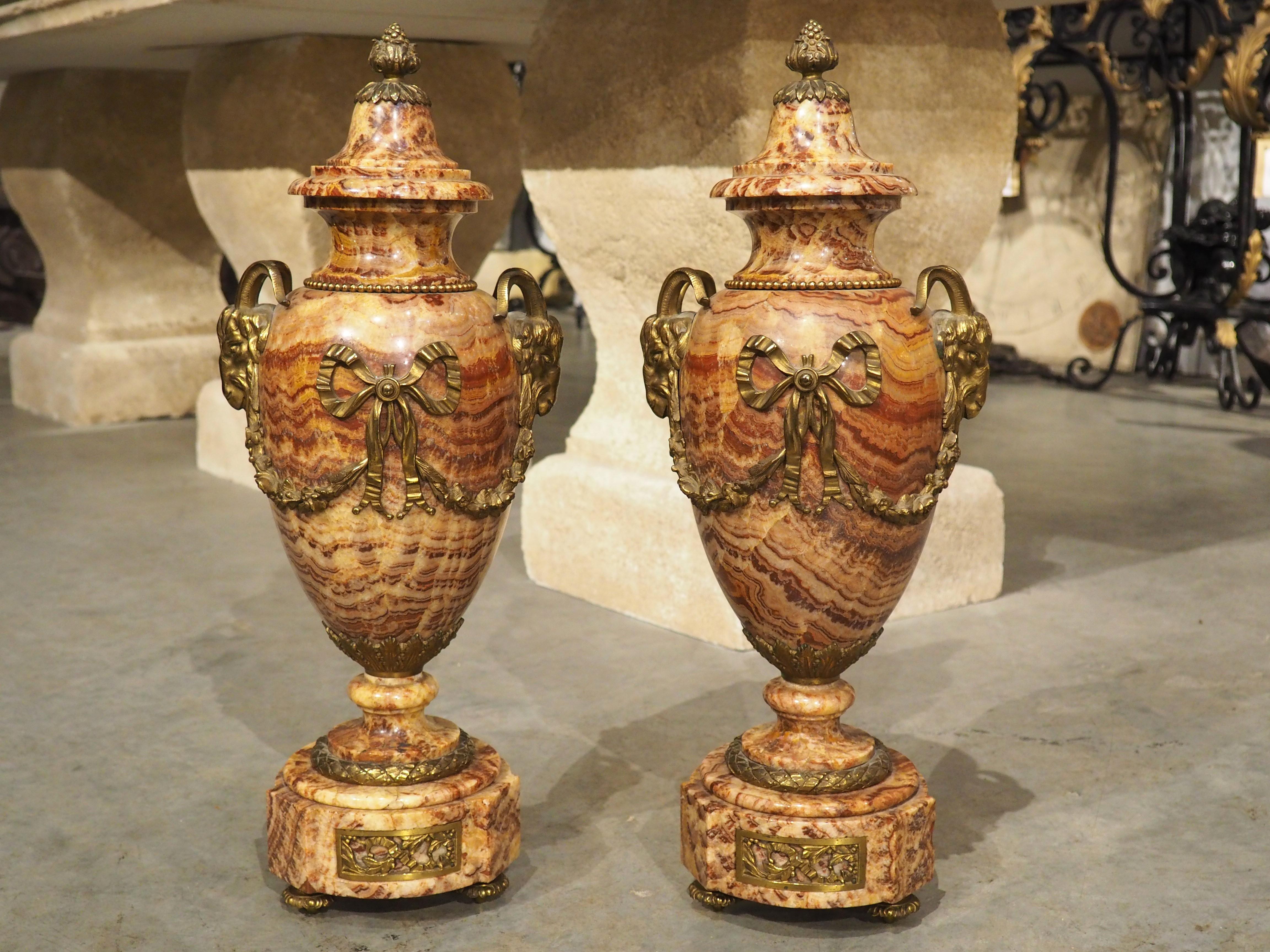 Although the origin of cassolettes can be traced back to ancient Europe and Asia, it was not until the late 18th century that cassolettes began to develop the urn-like form seen on this pair of marble and gilt bronze cassolettes. Our pair was