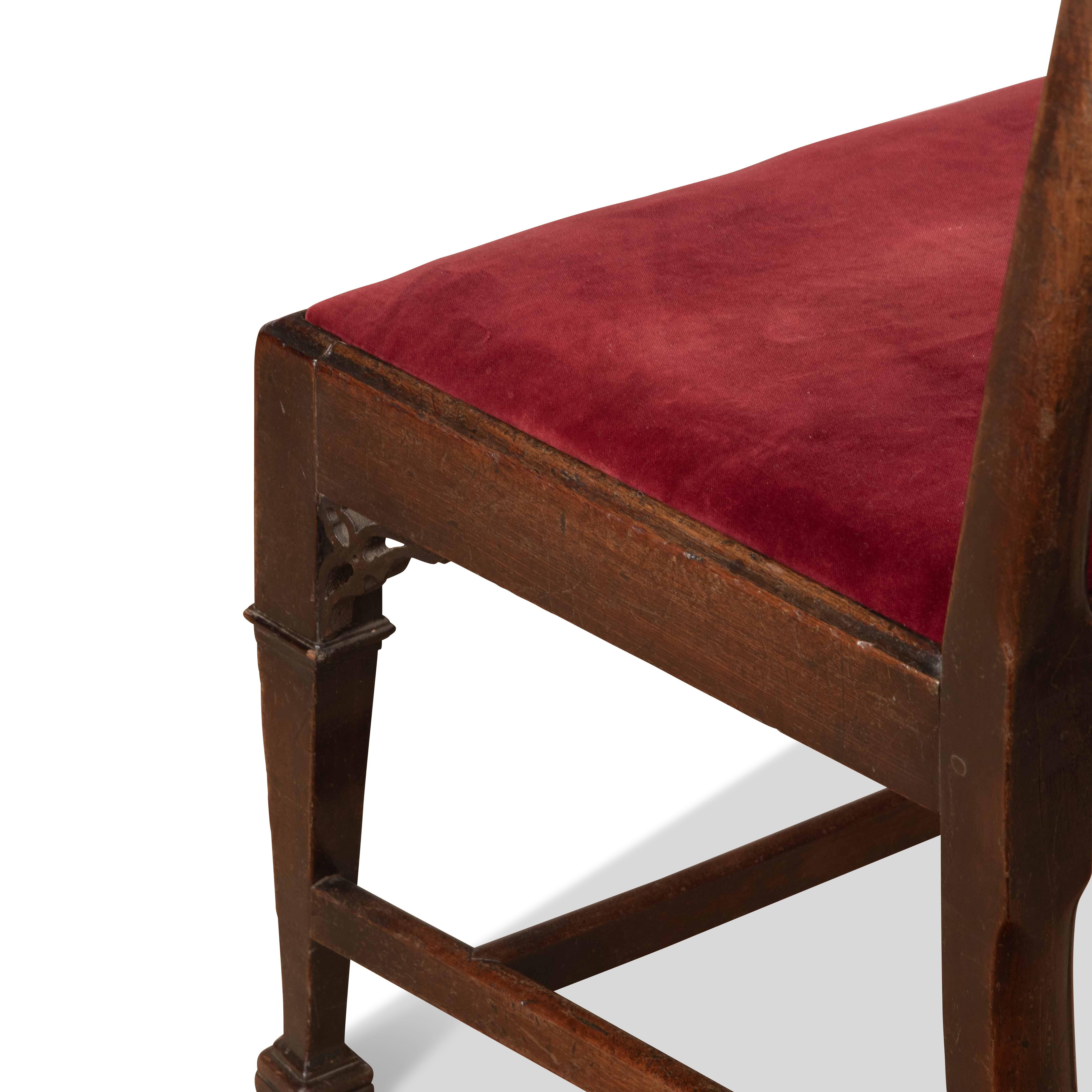 An unusual pair of 18th Century Mahogany Side Chairs. The top rails with scroll ears and central carved splats of architectural design, with pad seats below and raised on square tapering legs with original pierced carved corner brackets and