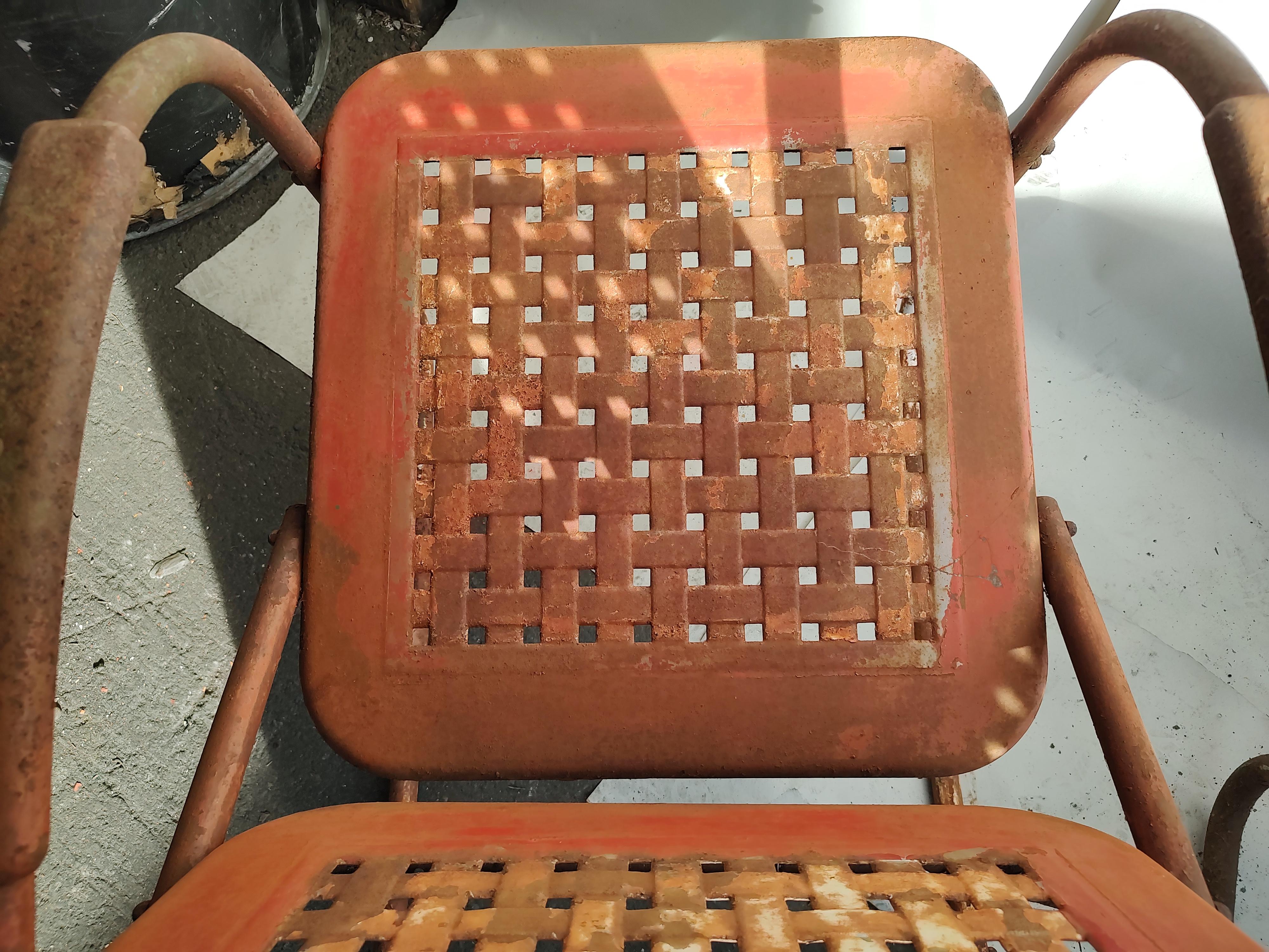 Pair of C1940 basket weave steel pierced porch chairs. Lots of patina, surface rust and original colors. One chair, blue has a dent in the seat corner. Otherwise all good structurally, ready to rock away.