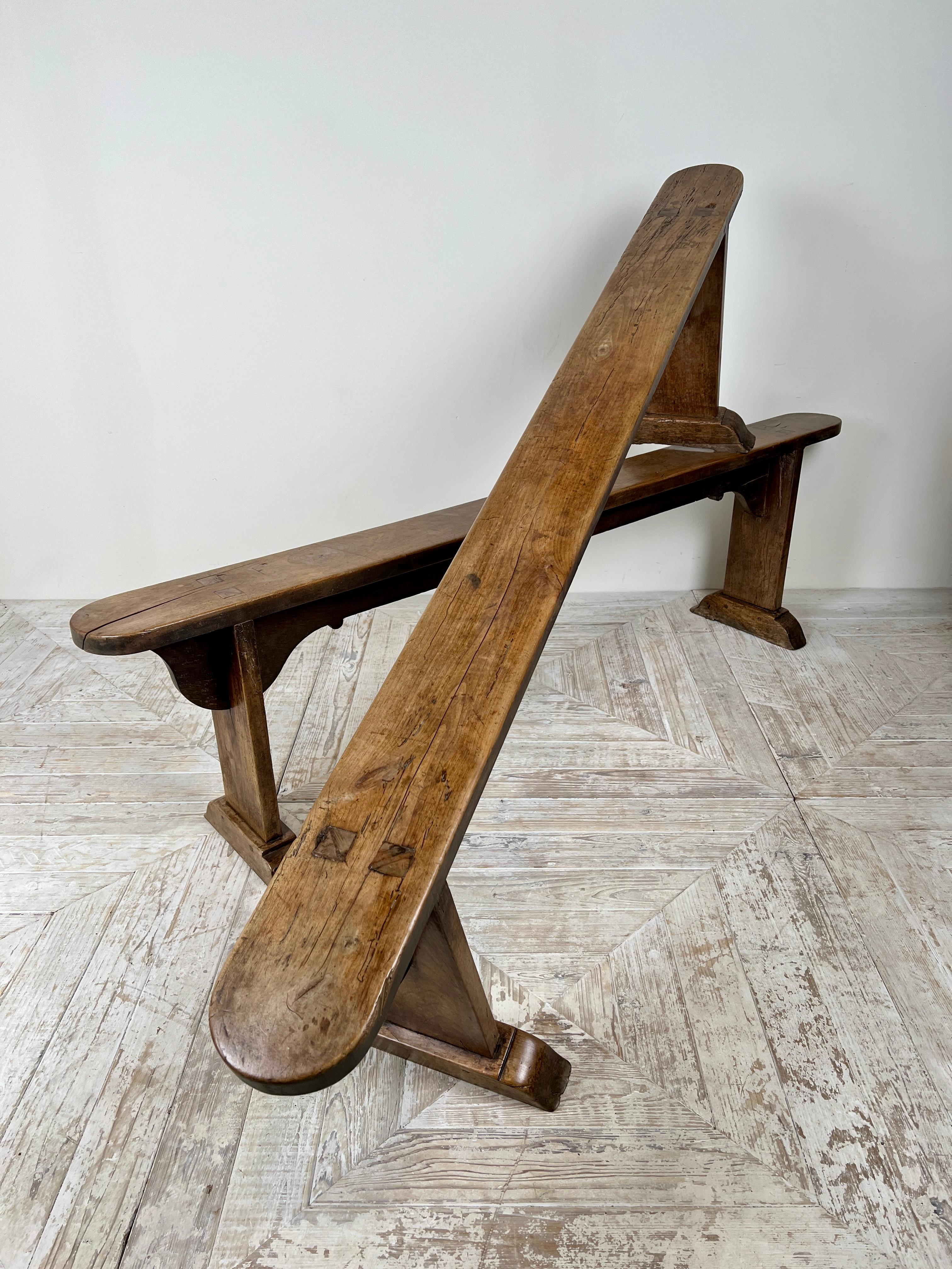 This wonderful pair of antique French fruitwood benches ranks among the nicest we have offered.

Their simply carved aprons give them an understated elegance, while decades of gentle aging have endowed the fruitwood with a wonderfully deep, warm