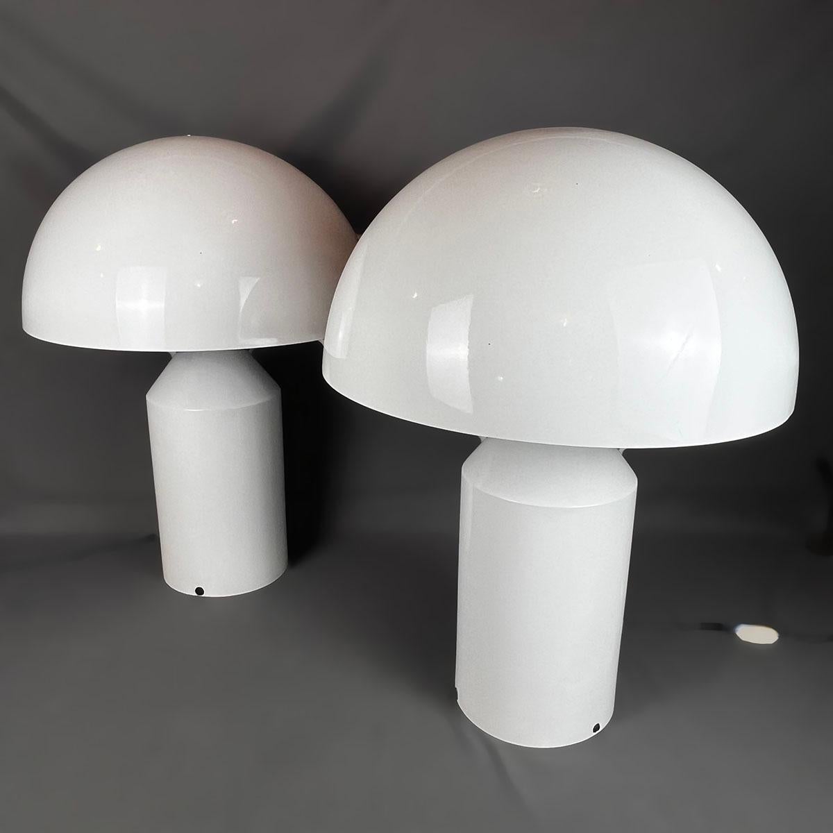 Coppia di lampade italiane Atollo 233 in alluminio bianco del 1979 ca. di Vico Magistretti per Oluce. Le lampade hanno la forma di funghi e contengono 2 lampadine ciascuna. 

Vico Magistretti (1920 - 2006) è stato un architetto, industrial designer,