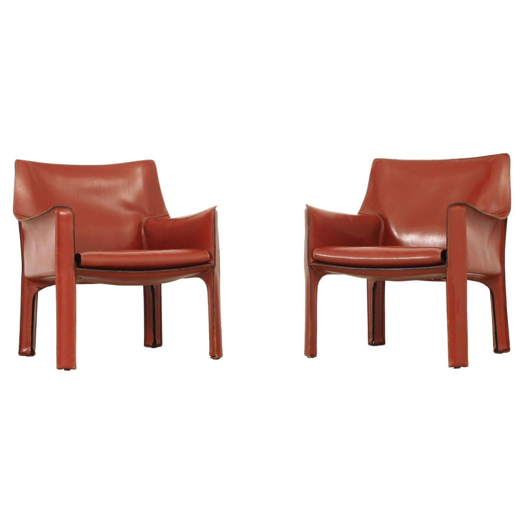 Pair of cab 414 armchairs designed by Mario Bellini in 1982 for Cassina, Italy. Steel frame covered with a thick red leather. Stamped with Cassina logo in the back of the seats.