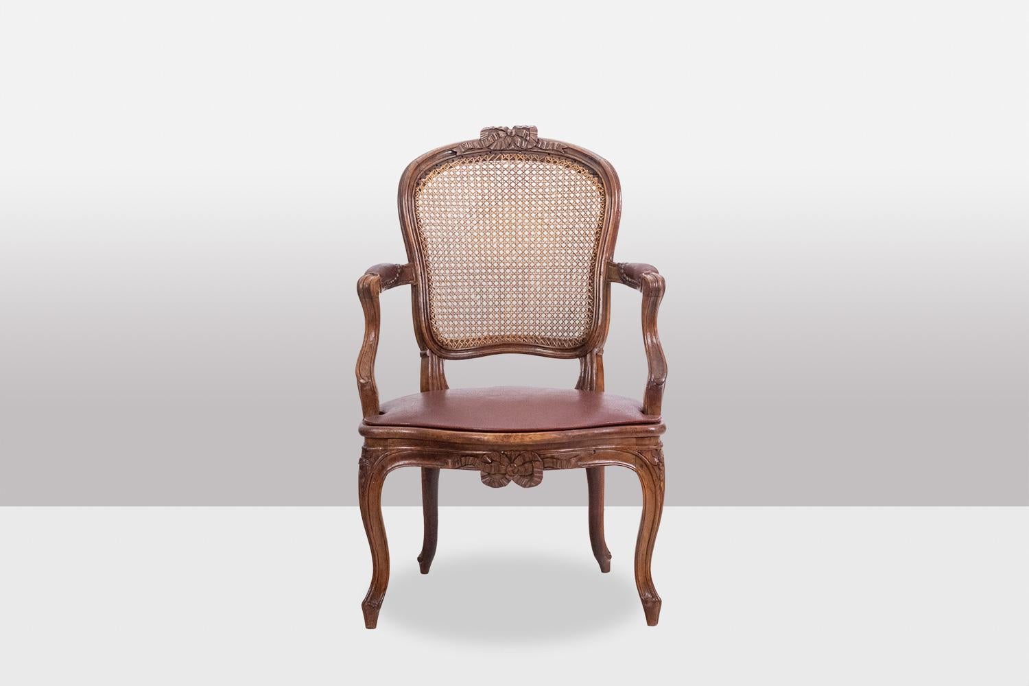 F.L., stamped.

Pair of “cabriolet” armchairs in walnut, decorated with ribbons at the top of the back and in the center of the belt. Cane seat and back, the seat covered with a leather pad in red tones. Curved base ending in a decoration of fine