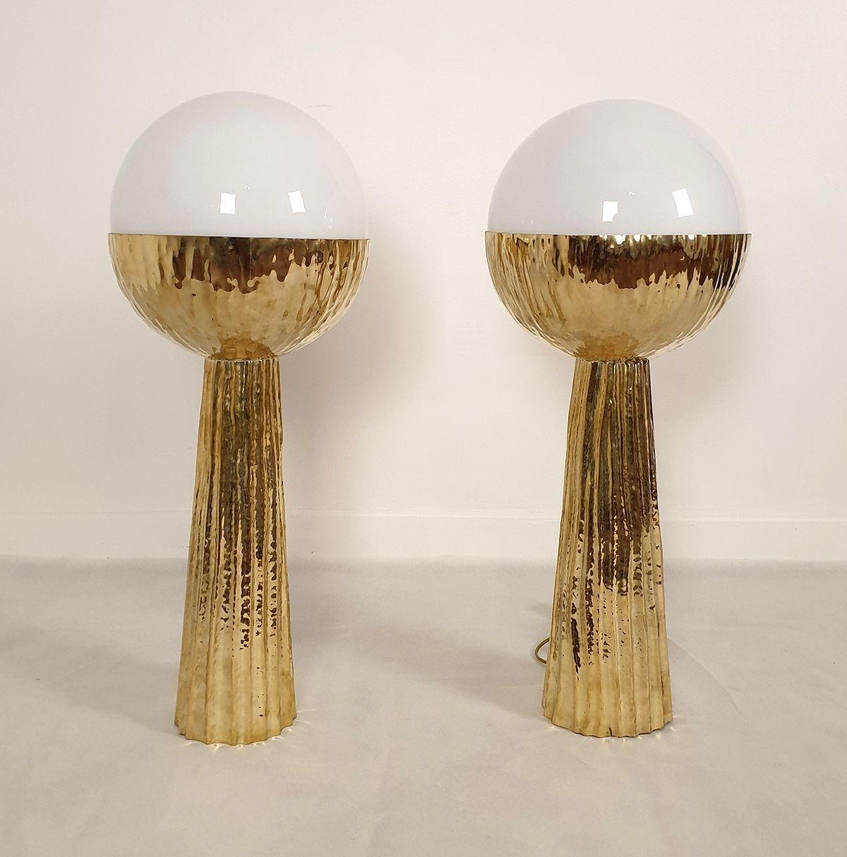 Pair of large cactus table lamps, Italy circa 2000s.
The Mid-Century Modern pair of lamps is made of hammered brass and a white glass globe, nesting the light.
The Italian lamps have been professionally rewired for the US. (Complimentary European