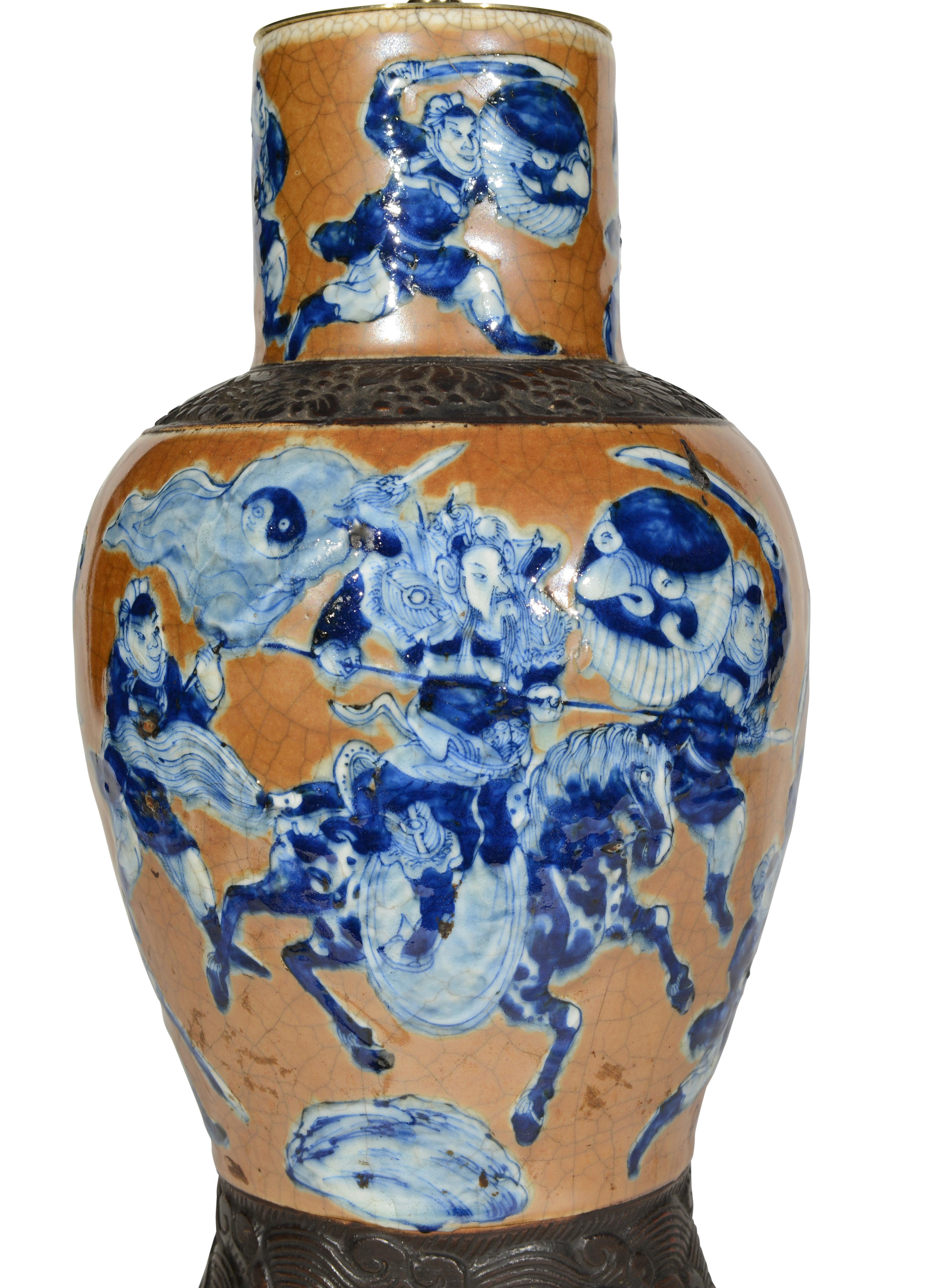 Très belle paire de vases balustres de la fin du XIXe siècle décorés de figures de guerriers en bleu et blanc sur un fond craquelé de café au lait avec des bandes stylisées bronzées, maintenant montés comme lampes de table avec des bases tournées