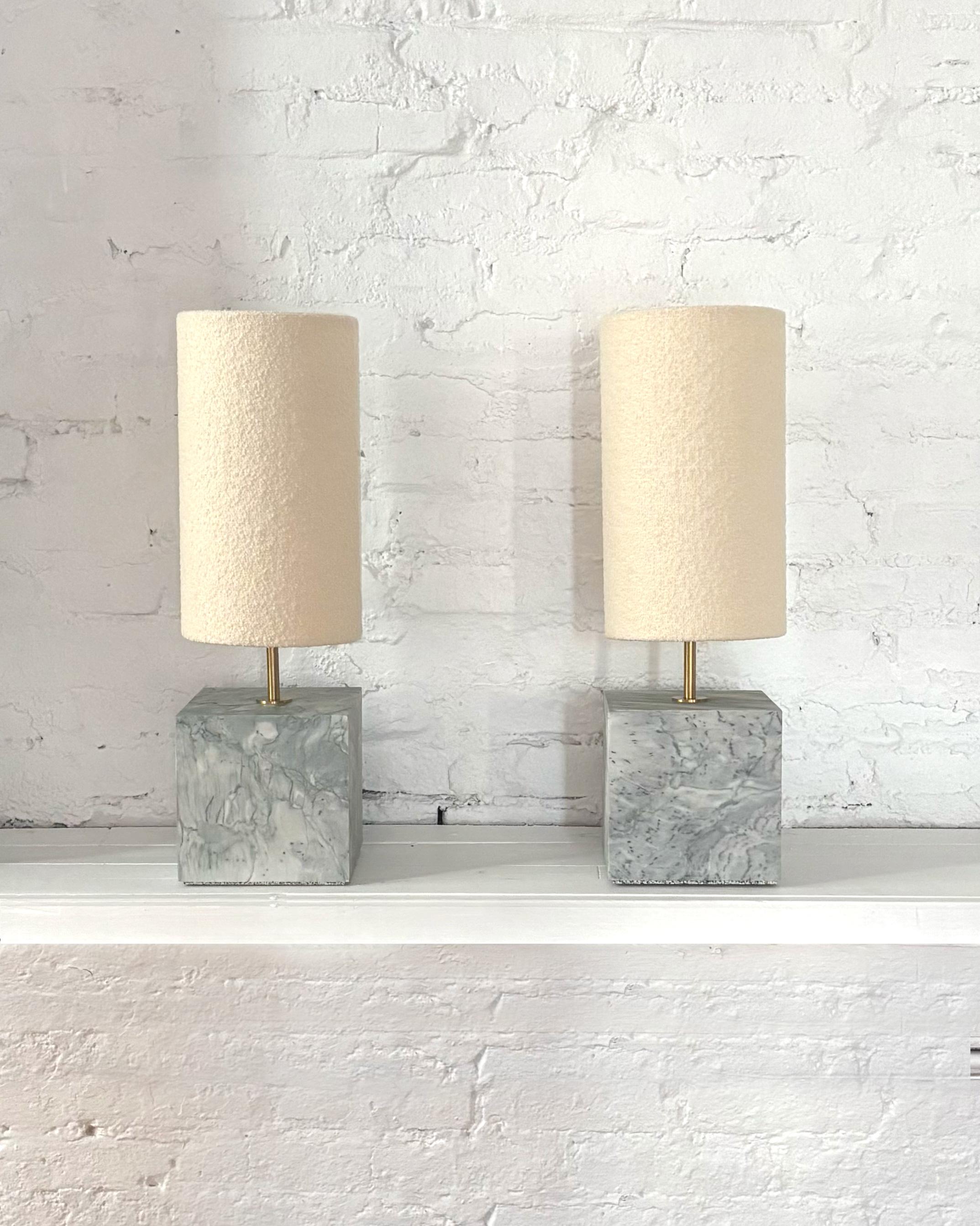 A rare and unique pair of Calacatta Turquoise Small Table Lamps with Boucle Shades with brass hardware. Brass dimmer on back face allows for expert light setting. 

The Coexist table lamp consists of a marble cube base and in this edition, the lamp