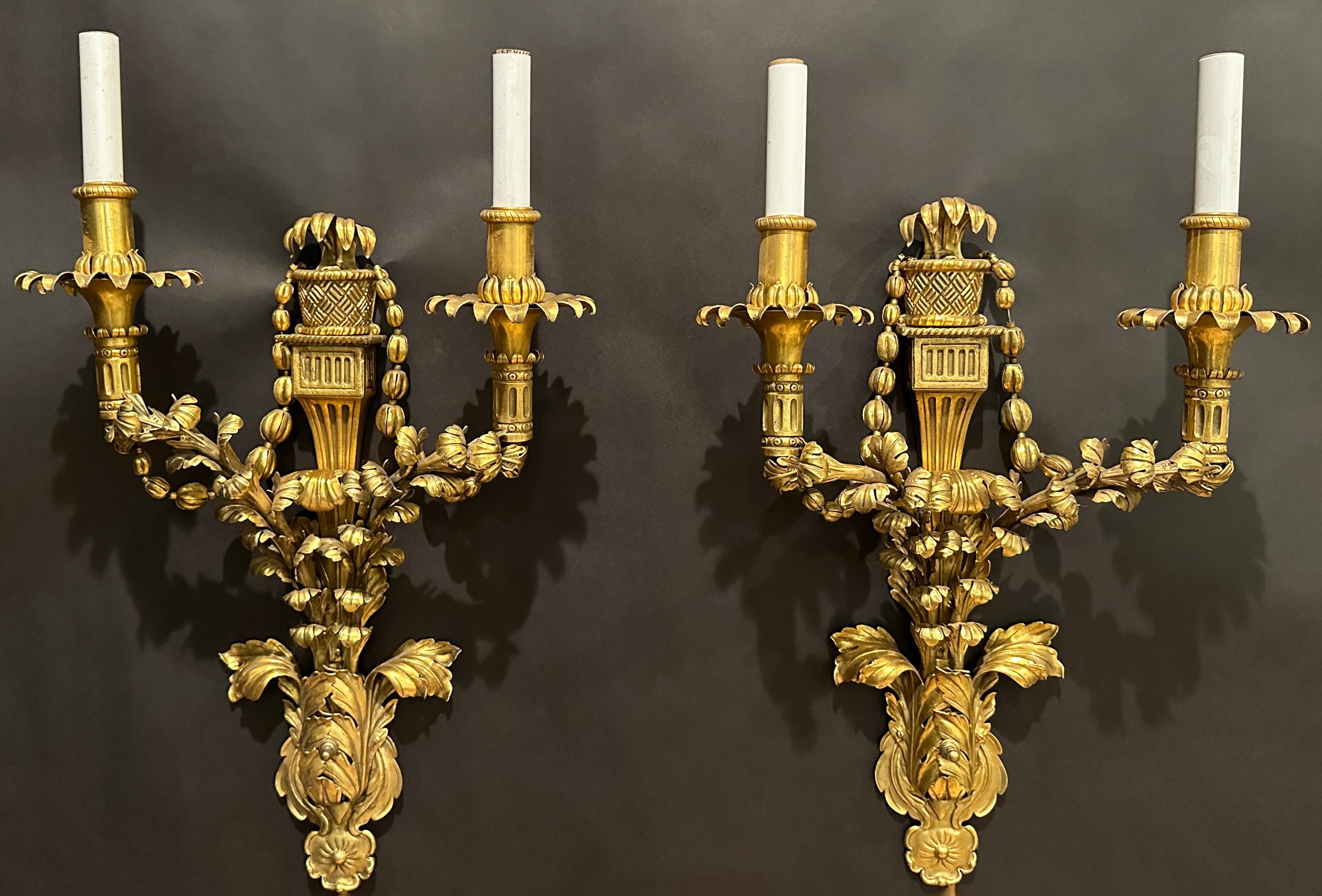 Antique gilt bronze electrified sconces, American, circa 1910. Floral design. Beautiful garland hangs from each light. Attributed to E.F. Caldwell & Co.