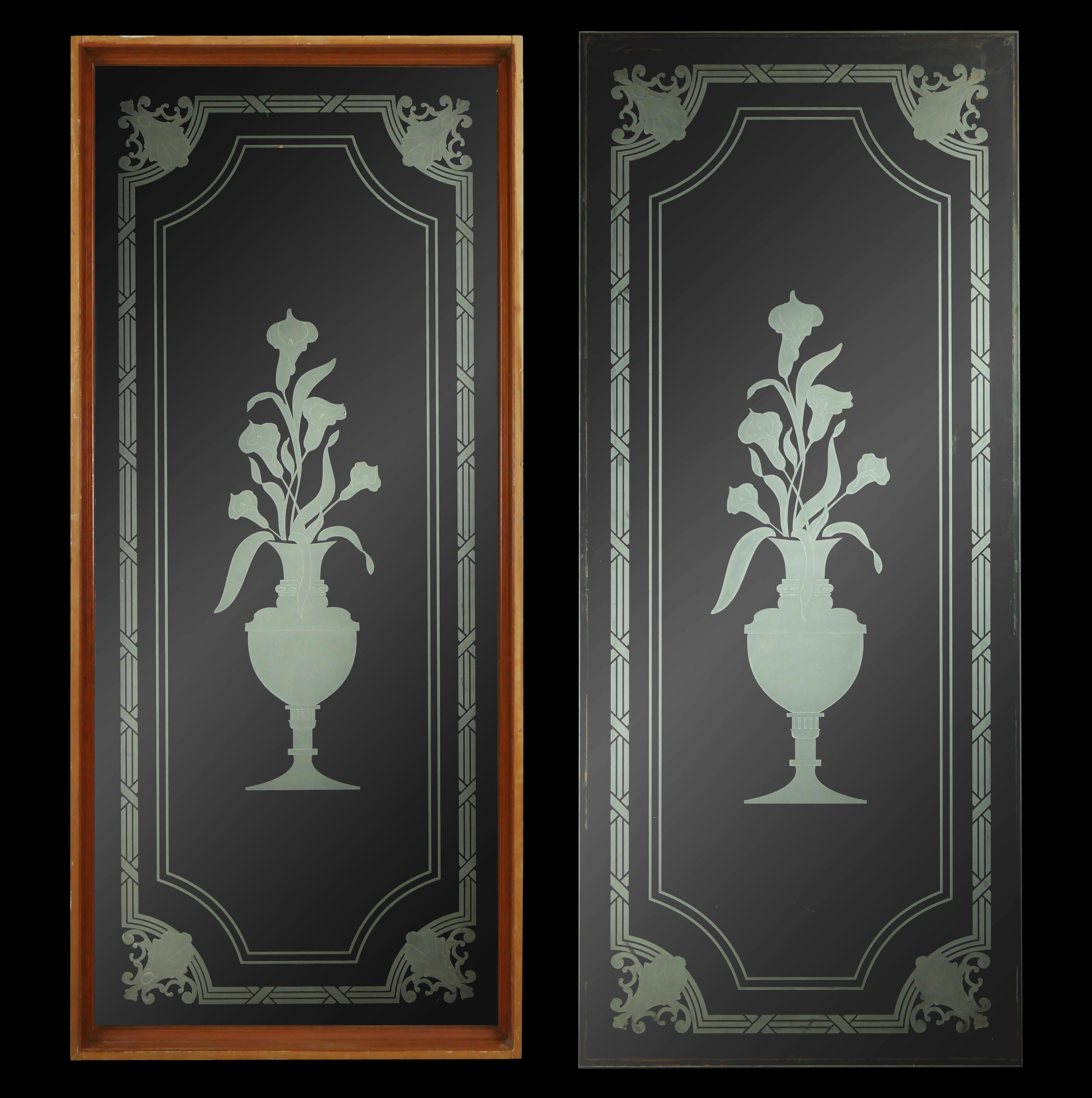 Reclaimed clear glass window panels with an etched ornate frame and a bundle of calla lilies in an urn vase. One panel has a wood frame and the other is just the glass. Both surfaces of the glass do have some wear. Sold as is. Priced as a pair.