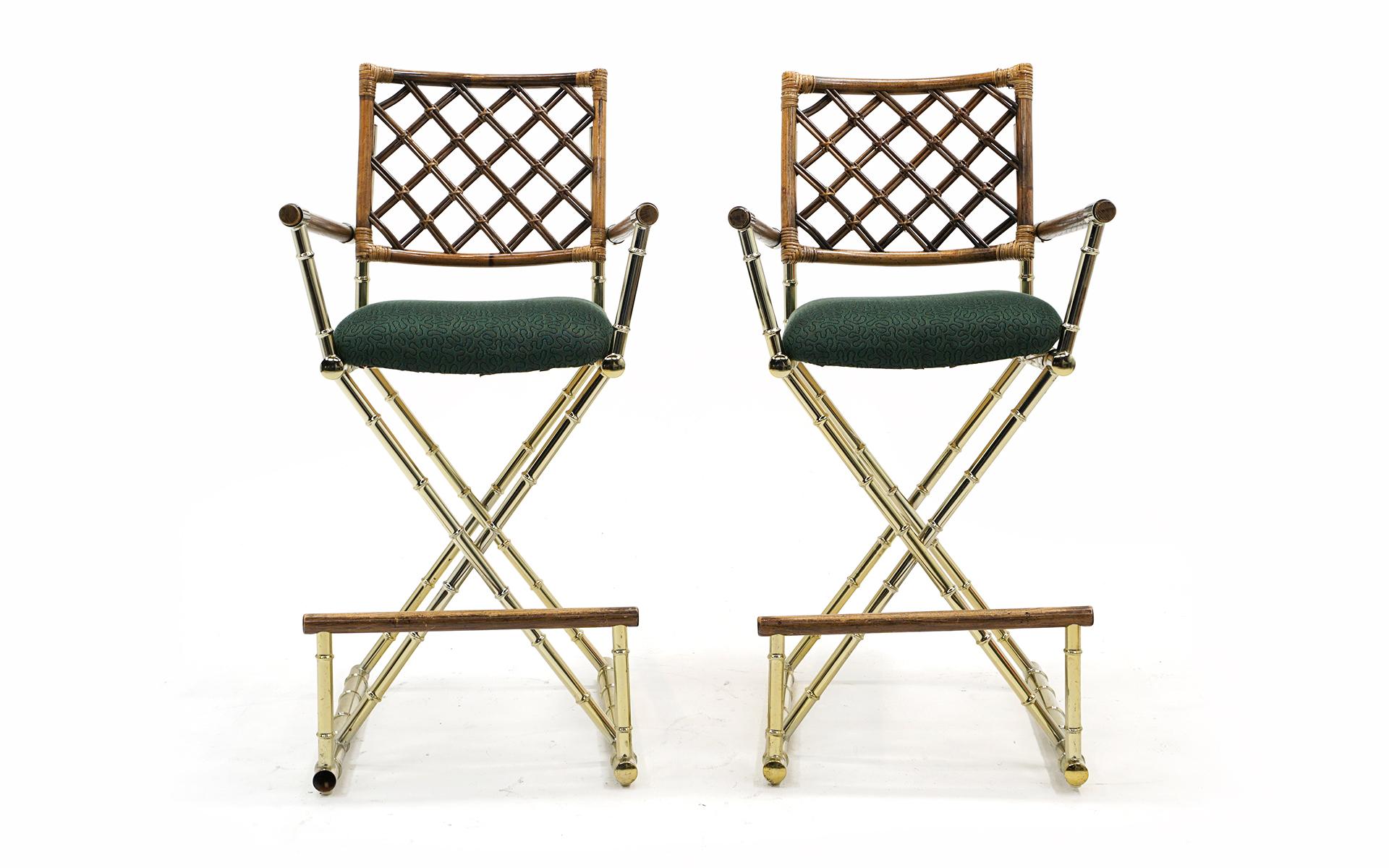 Pair (two) campaign style barstools with faux bamboo brass frames, with bamboo and rattan arms, seat backs, and footrests. Green upholstered seats are in good condition as well, but would also be an easy redo. Both stools are sturdy and ready to use.