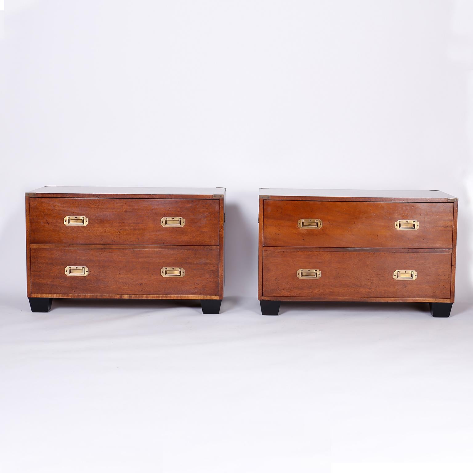 Pair of campaign style two drawer stands crafted in mahogany with brass hardware and ebonized tapered block feet. Perfect marriage of an antique concept with a modern form. Possibly by Charlotte Horstmann of Hong Kong.