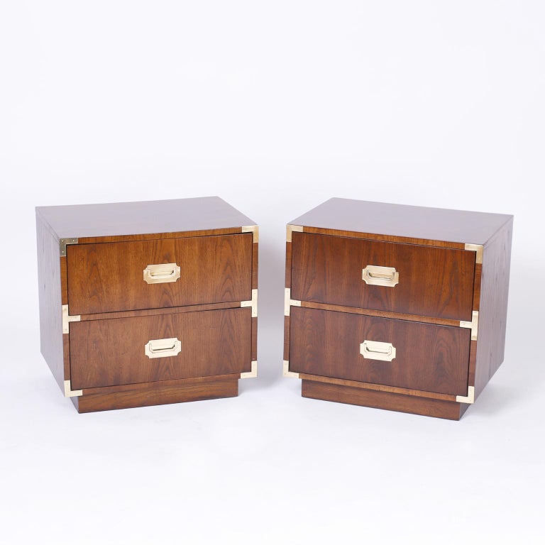 Pair of vintage Campaign nightstands crafted in walnut with sleek modern form, brass Campaign hardware and block feet. Stamped 