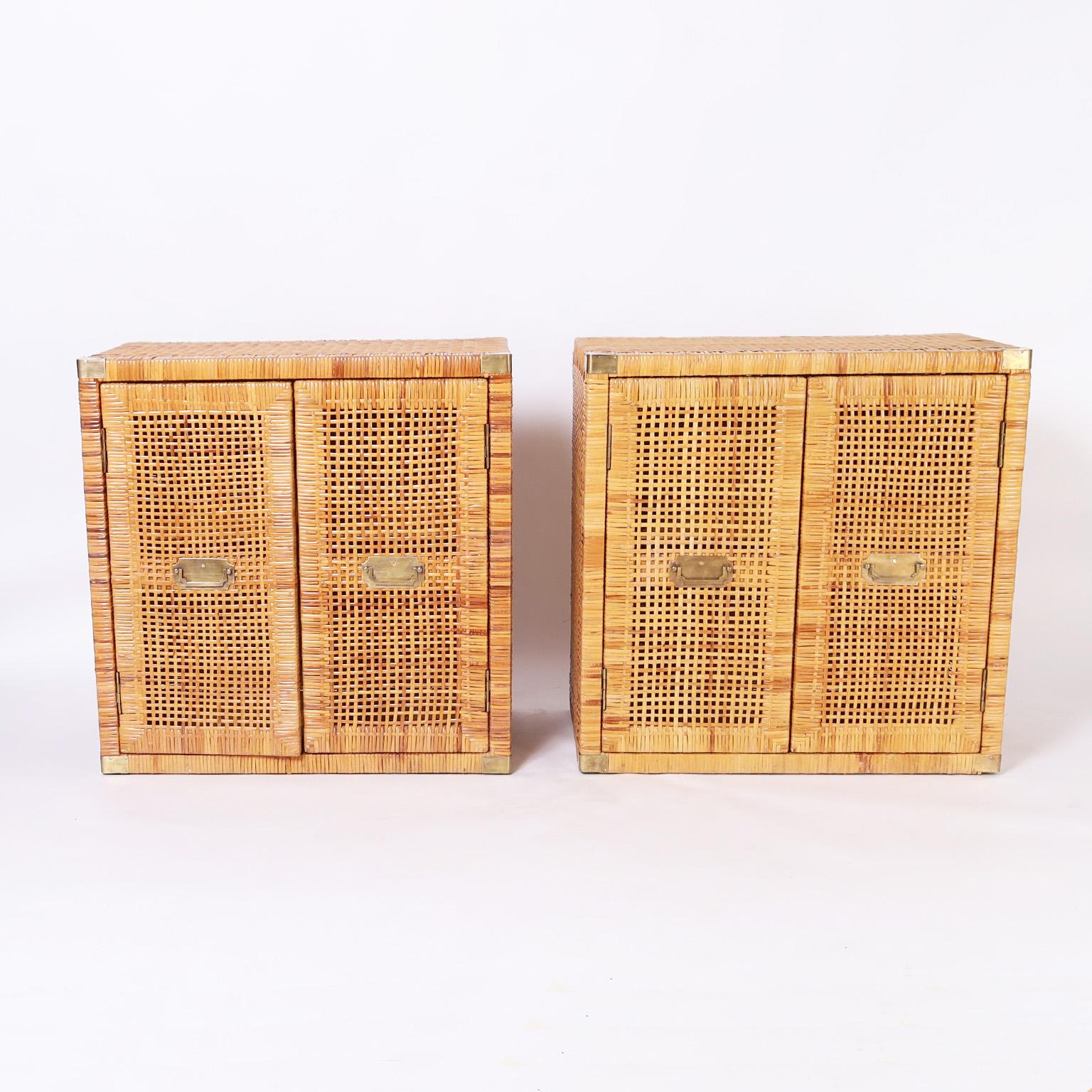 Impressive pair of vintage Bielecky Brothers stands hand crafted in woven reed in a campaign style with brass hardware, two doors in front, and plenty of storage.