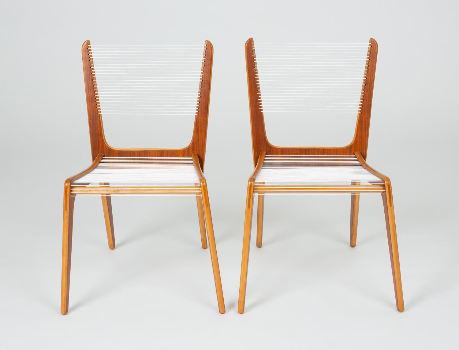 A pair of delicate accent chair by French Canadian designer Jacques Guillon. Designed in 1953, nearly transparent design consists of three interlocking wooden pieces stacked maple plywood faced with a contrasting walnut veneer joined by a wooden