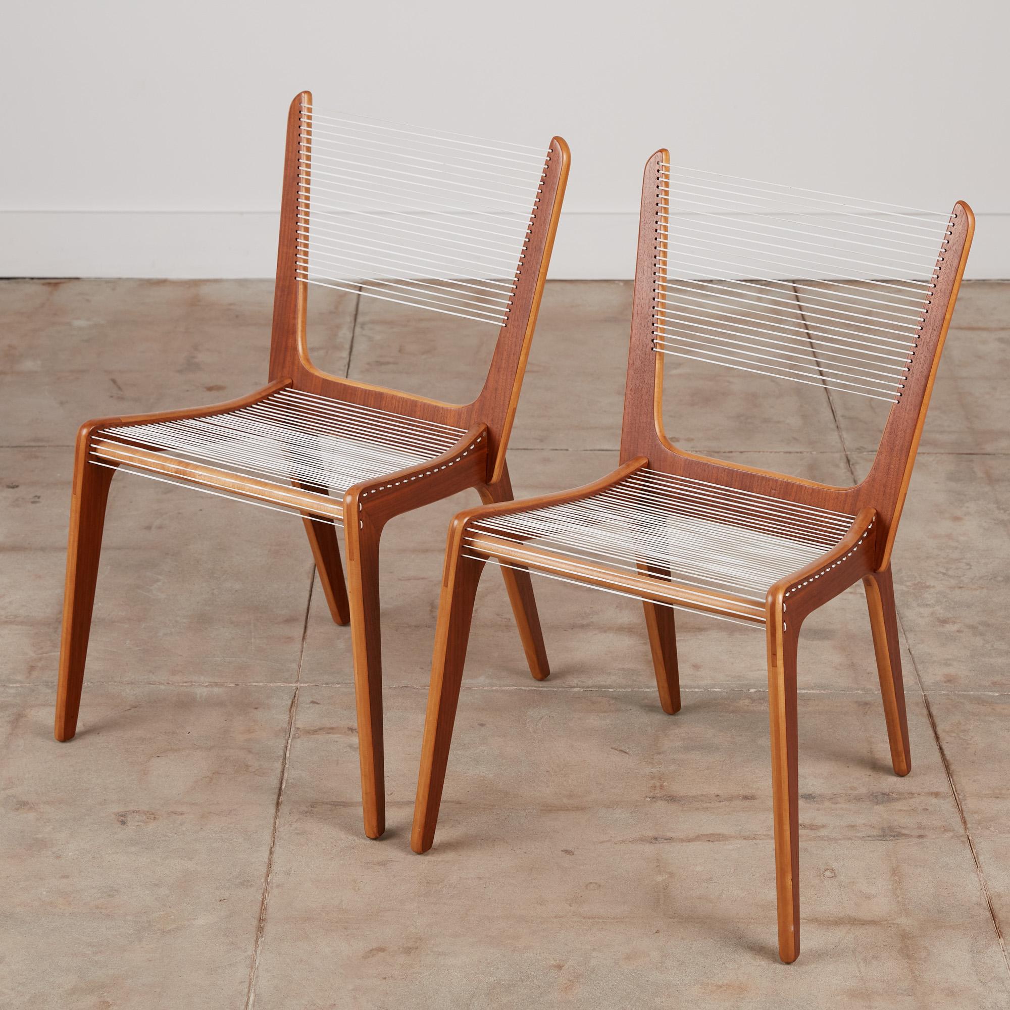 A pair of delicate accent chair by French Canadian designer Jacques Guillon. Designed in 1953, nearly transparent design consists of three interlocking wooden pieces stacked maple plywood faced with a contrasting walnut veneer joined by a wooden