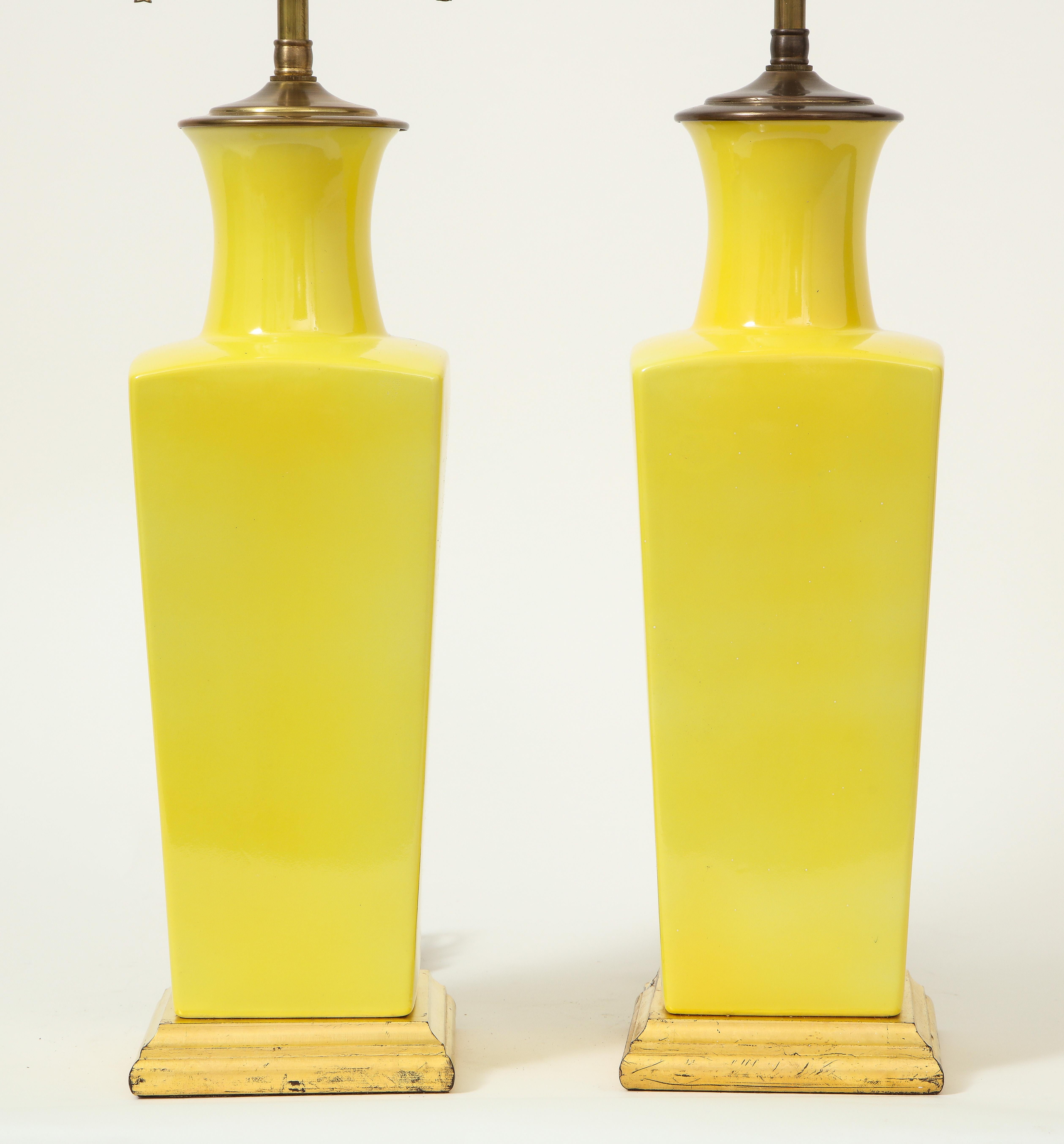 Chacune de forme carrée et effilée montée sur une base dorée tournée, équipée d'une tige en laiton réglable et de douilles à deux lumières, la hauteur du vase est de 15.5