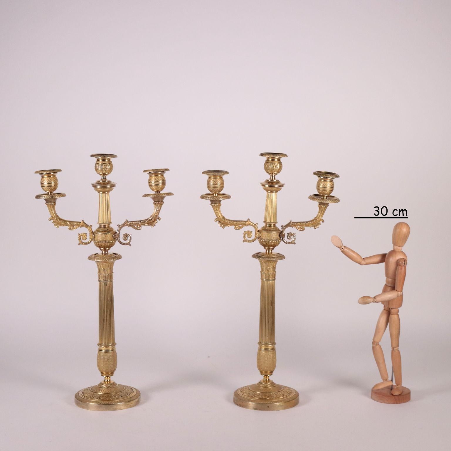 Pair of candelabra with three lights, finely chiselled bronze and gilded with mercury. Vegetal embossed decorations and spiral branches.