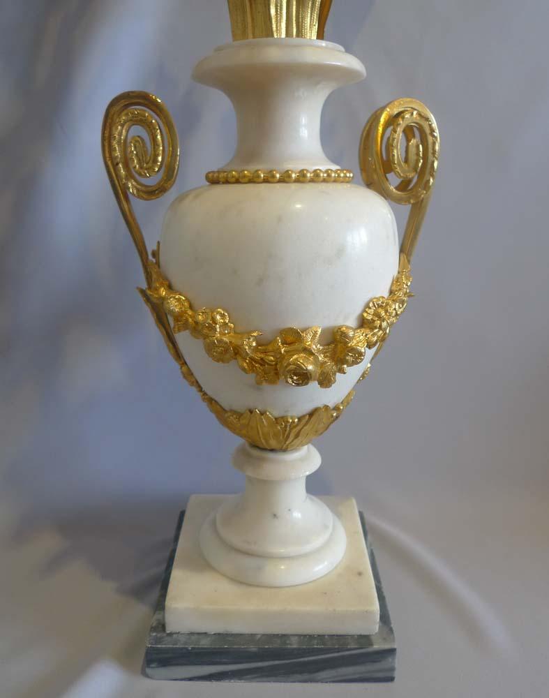 Coppia di candelabri francesi in stile Luigi XVI, in marmo bianco e blu di Tarquinio, con montature e portacandele originali in ormolu. In ottimo stato di conservazione con l'ormolatura praticamente intatta, poggiano su basi di Tarquinio blu sotto