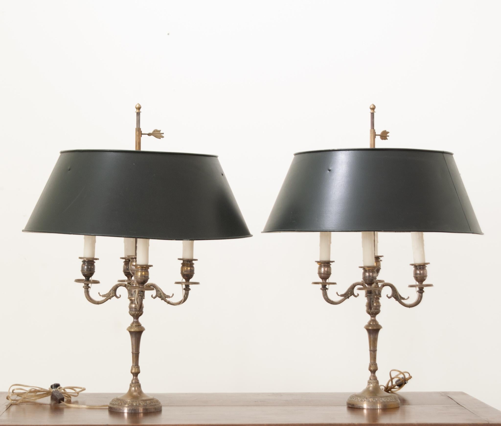 Un par de candelabros franceses plateados convertidos en lámparas bouillotte con pantallas nuevas de metal negro. La Bouillotte es un juego de cartas que se hizo popular en Francia durante los siglos XVIII y XIX. Para la luz, utilizaban una lámpara