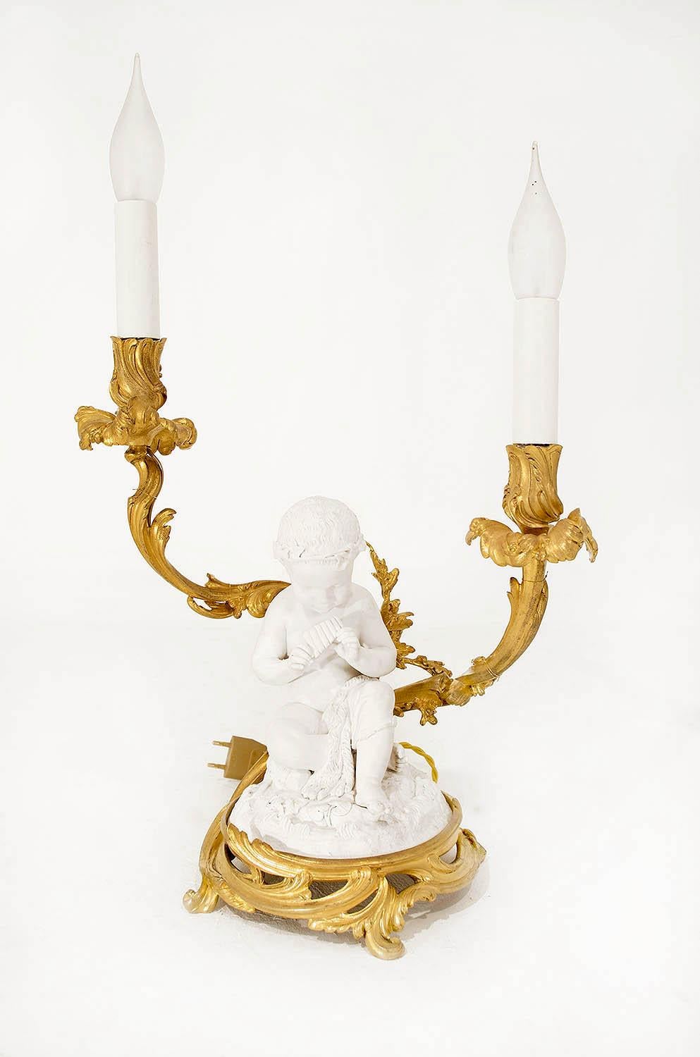 Pair of Louis XV style candelabra in Sèvres porcelain biscuit and gilt bronze, figuring two putti musicians.
Mounted on a rocaille gilt bronze circular base with two candle branches with acanthus leaves decor. The seated children are dressed with