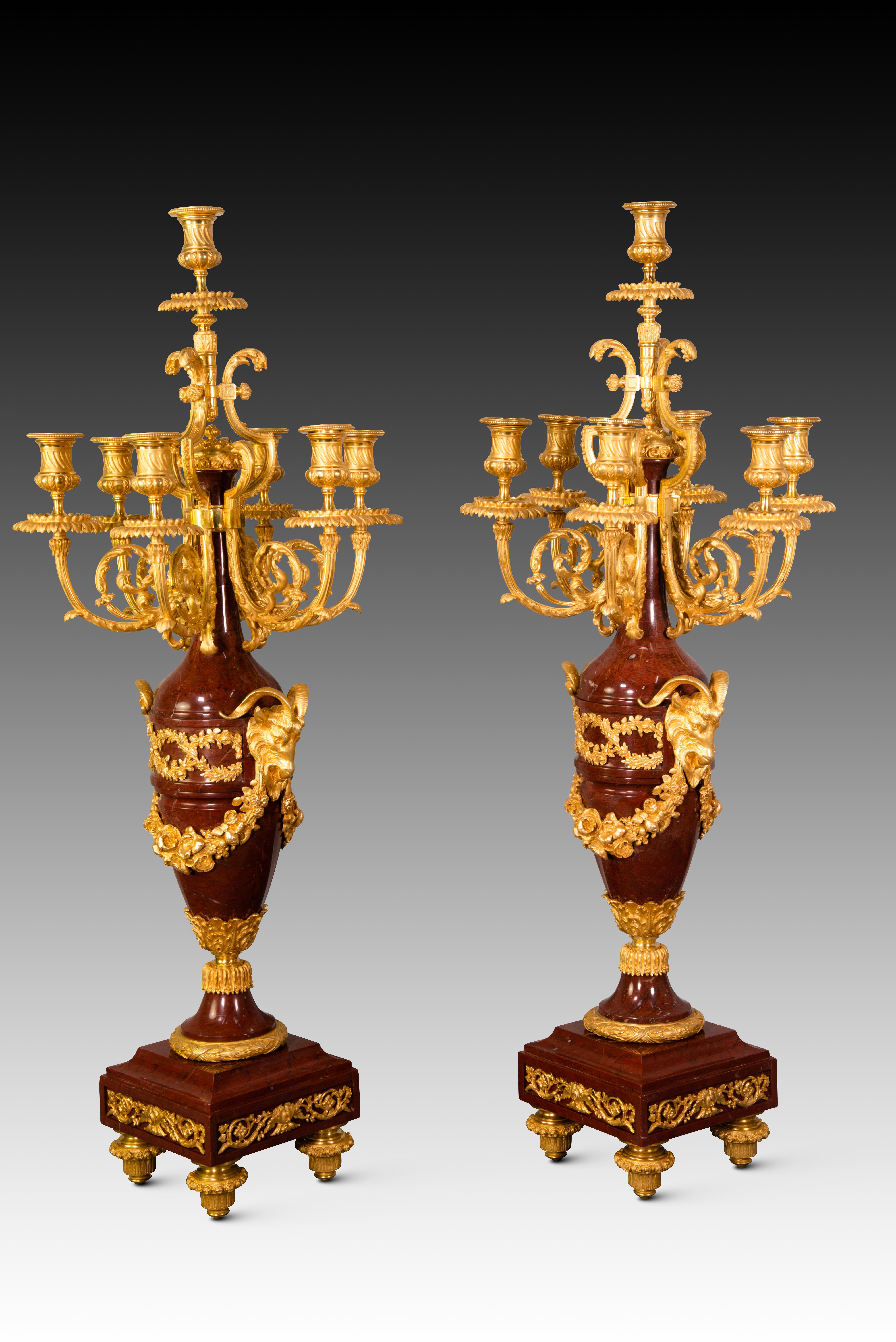 Pair of candelabras. Rouge Griotte marble, gilt bronze. France, possibly Napoleon III, 19th century. 
Pair of candelabras with seven lights each made of marble and mercury-gilded bronze. The base, raised on four legs, presents vegetal borders around
