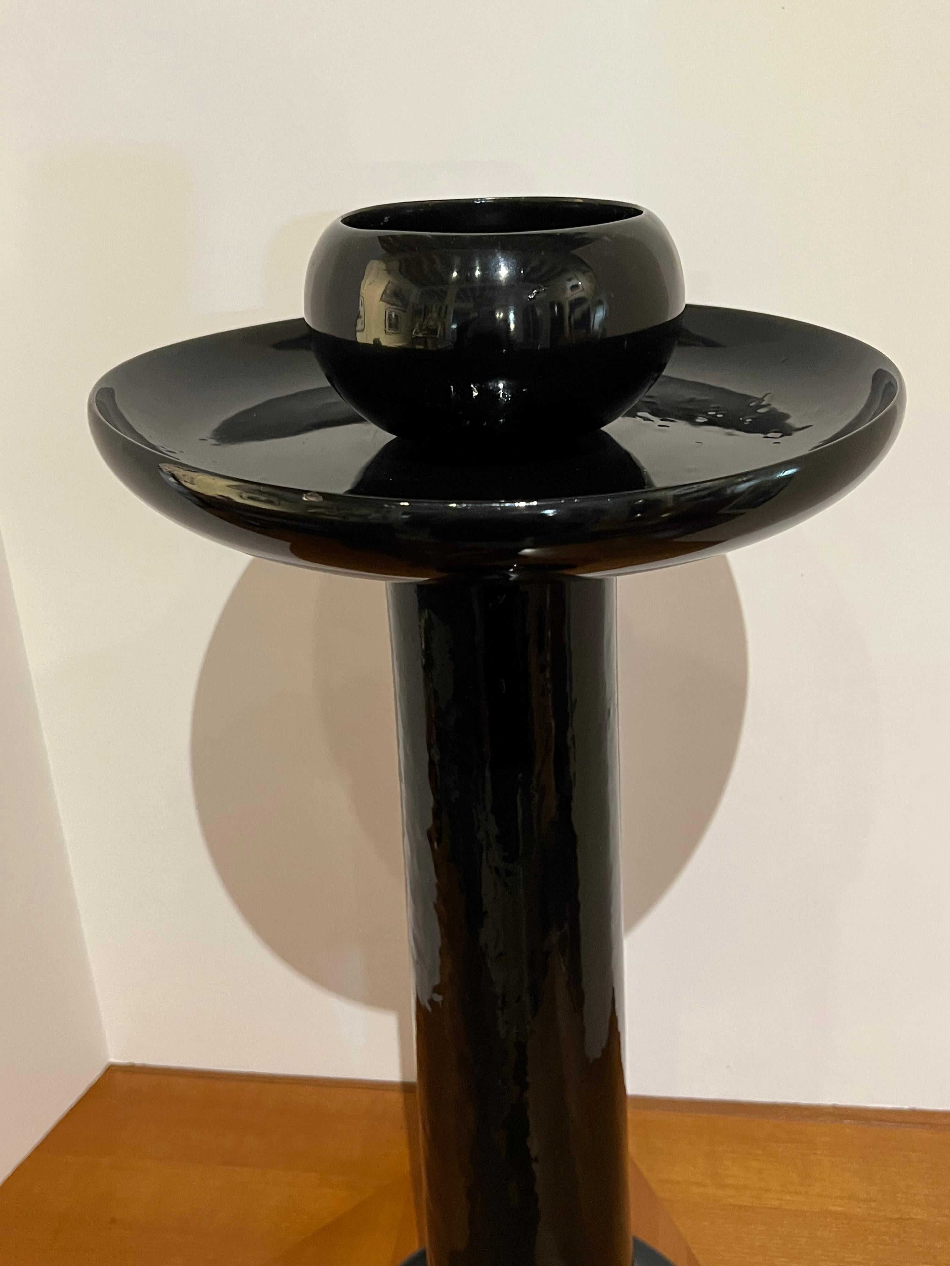 A pair of tall 1980s candleholders made of glossy black resin. They could hold two candlesticks or be used like little vases.
