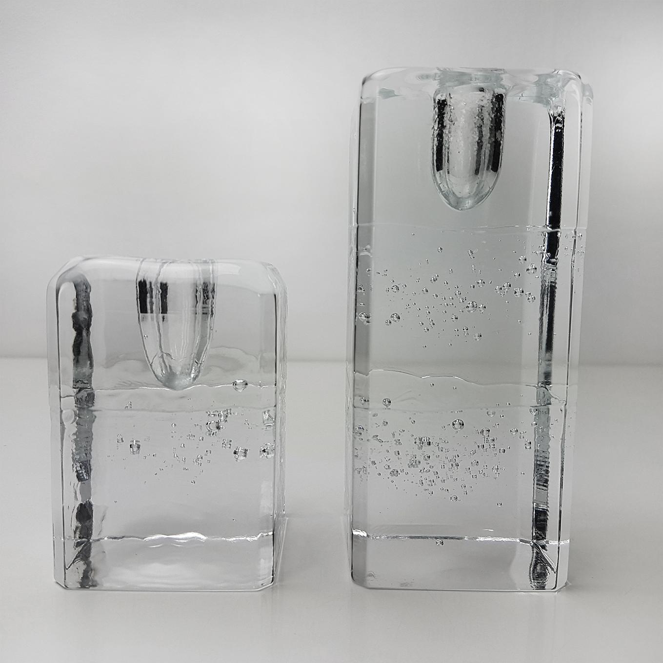 This pair of square candleholders designed by Timo Sarpaneva for Iittala, Finland are heavy, substantial and gorgeous. With large and small suspended bubbles and wrinkled glass, they look as if they are chiseled from a solid block of ice. Inspired