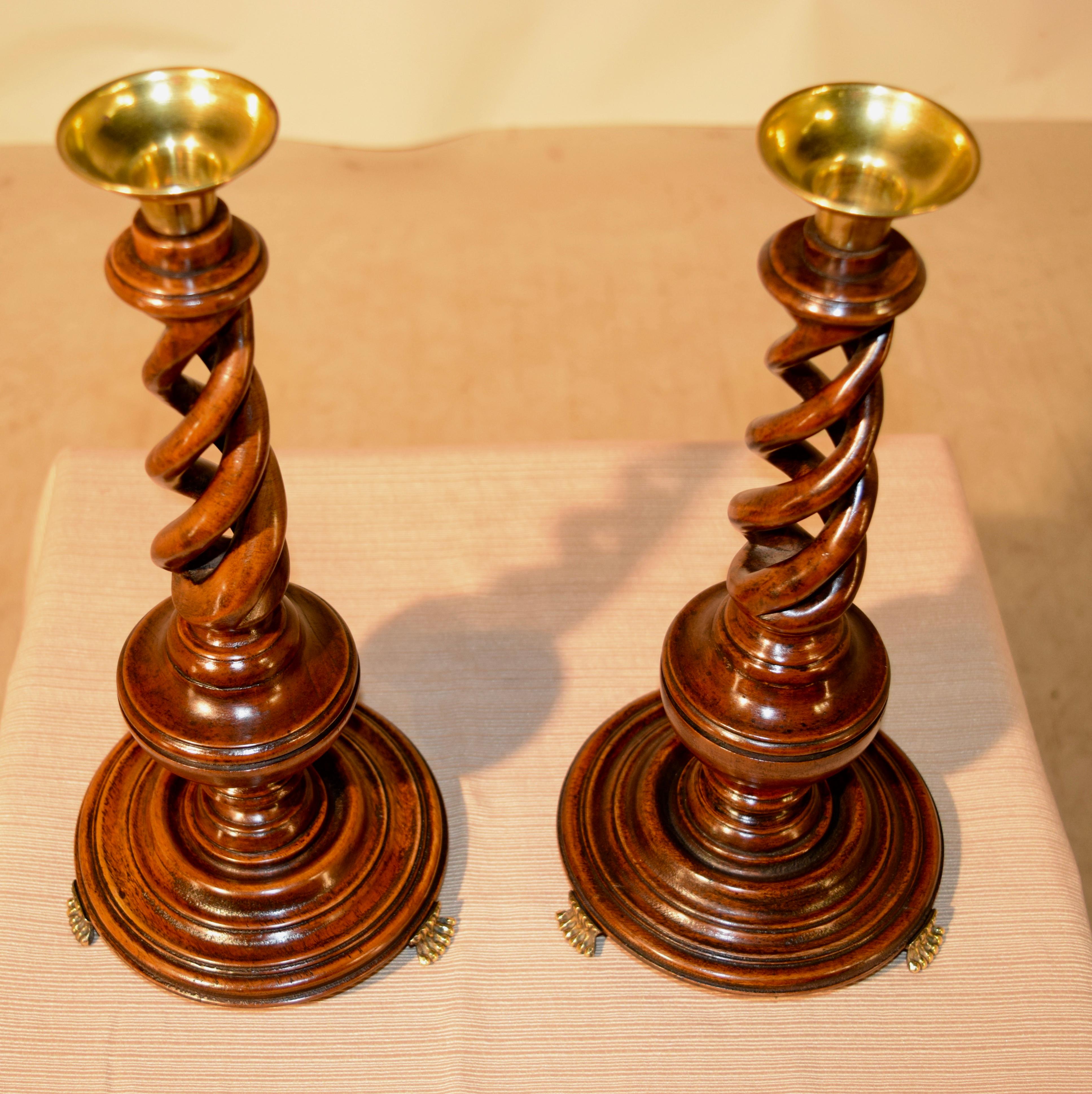 Pair of open triple twist mahogany candlesticks from England, circa 1900. The brass candle cups follow down to exquisitely hand turned open triple twist stems over hand turned bulbous turnings with lovely hand turned bases, supported upon hand cast