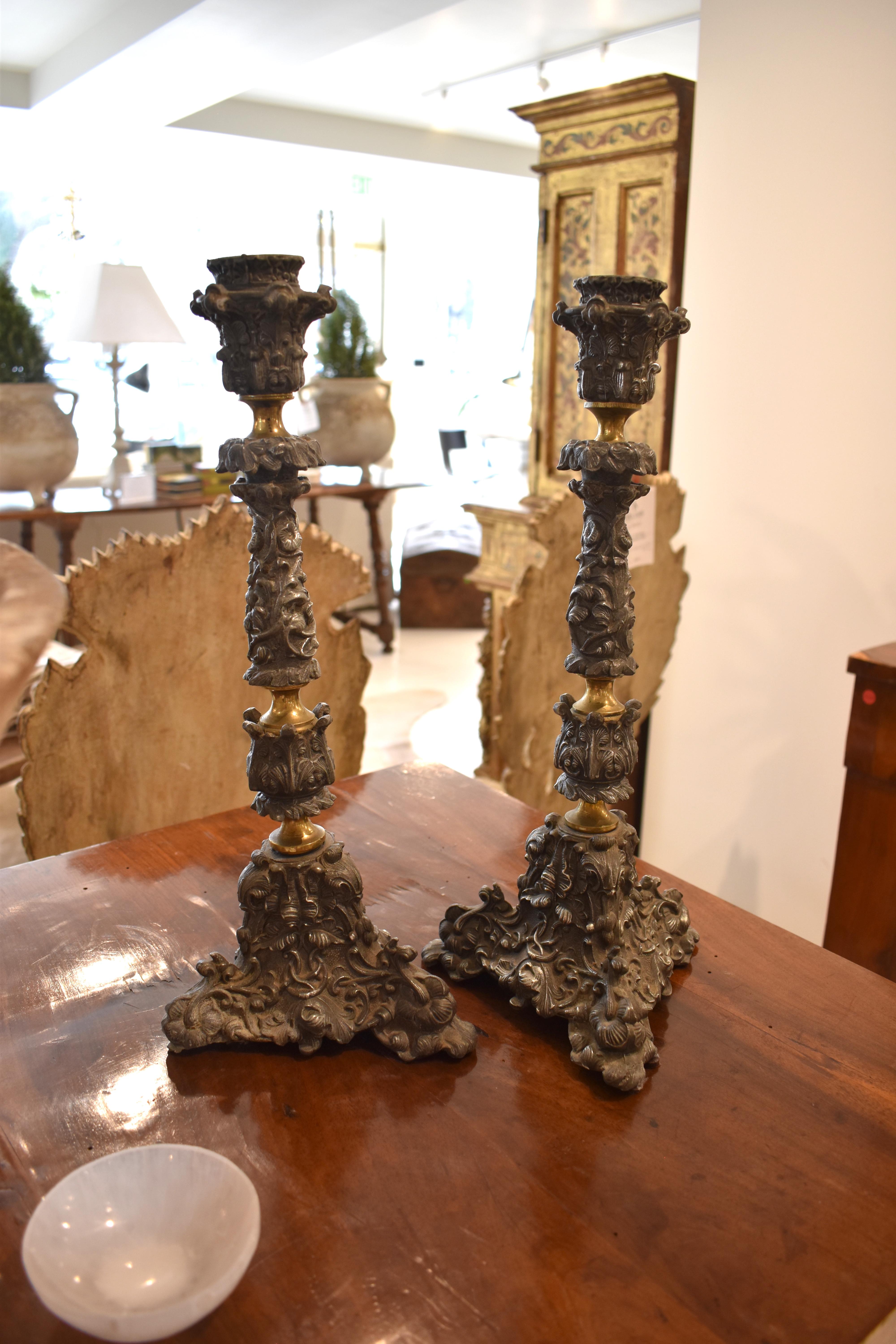 Paire de chandeliers en étain français du XIXe siècle, richement sculptés, sur des bases tripodes.