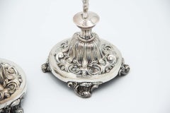 Pair of candlesticks in embossed silver with cherub figures