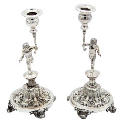 Pair of candlesticks in embossed silver with cherub figures