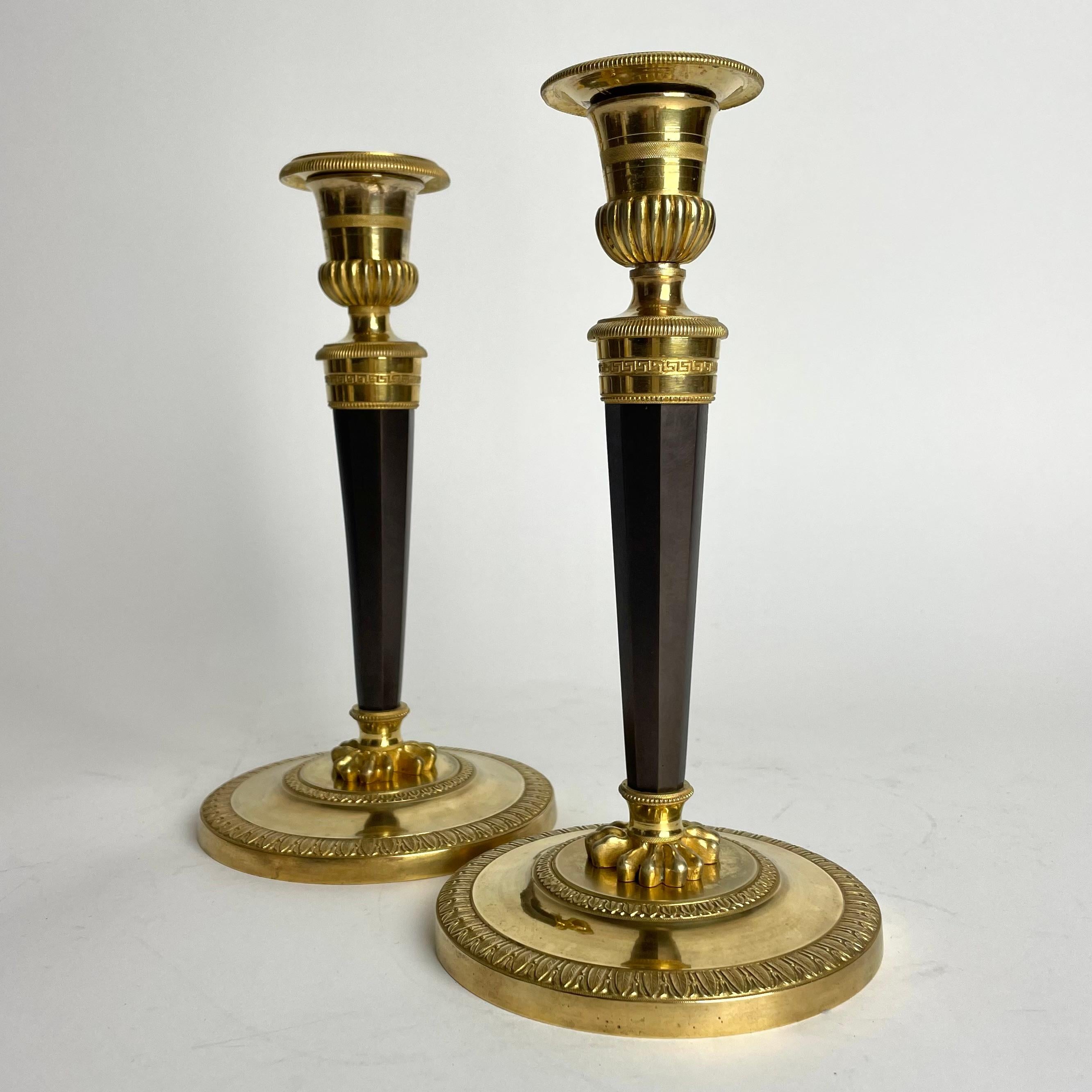 A pair of very sophisticated Candlesticks in gilded and darkpatinated bronze. Probably made in Paris, France during the Directoire, circa 1795.

Wear consistent with age and use.