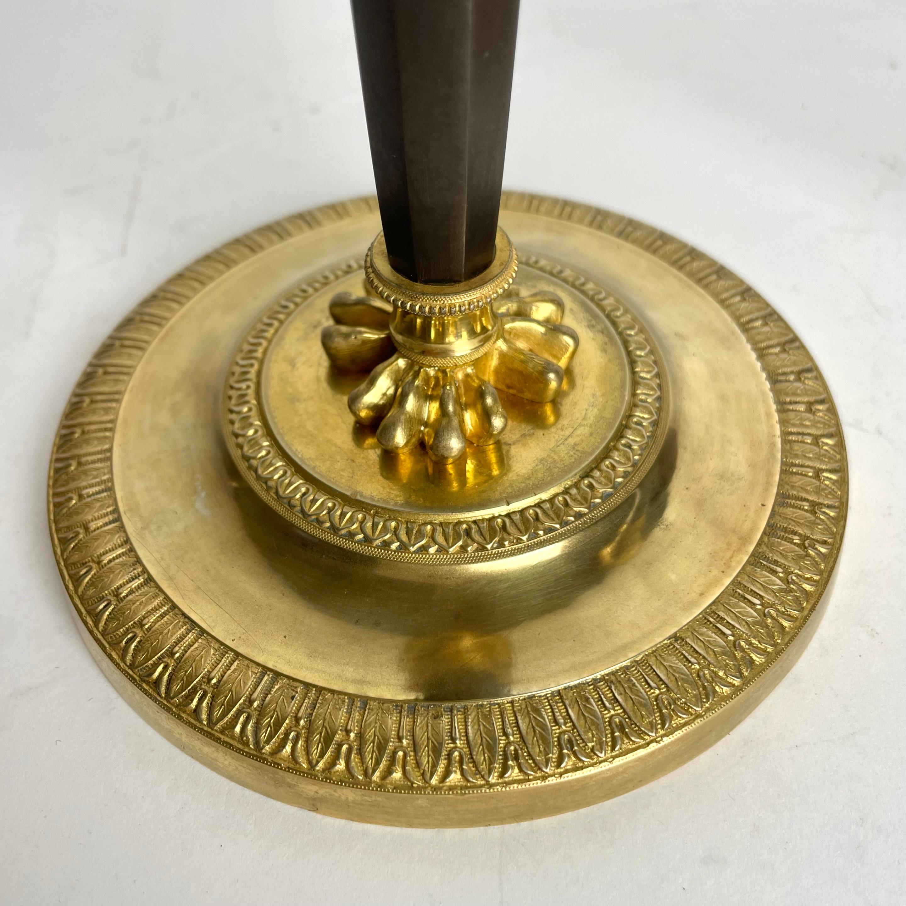 Gilt Pair of Candlesticks in gilded and darkpatinated bronze. Directoire circa 1795 For Sale