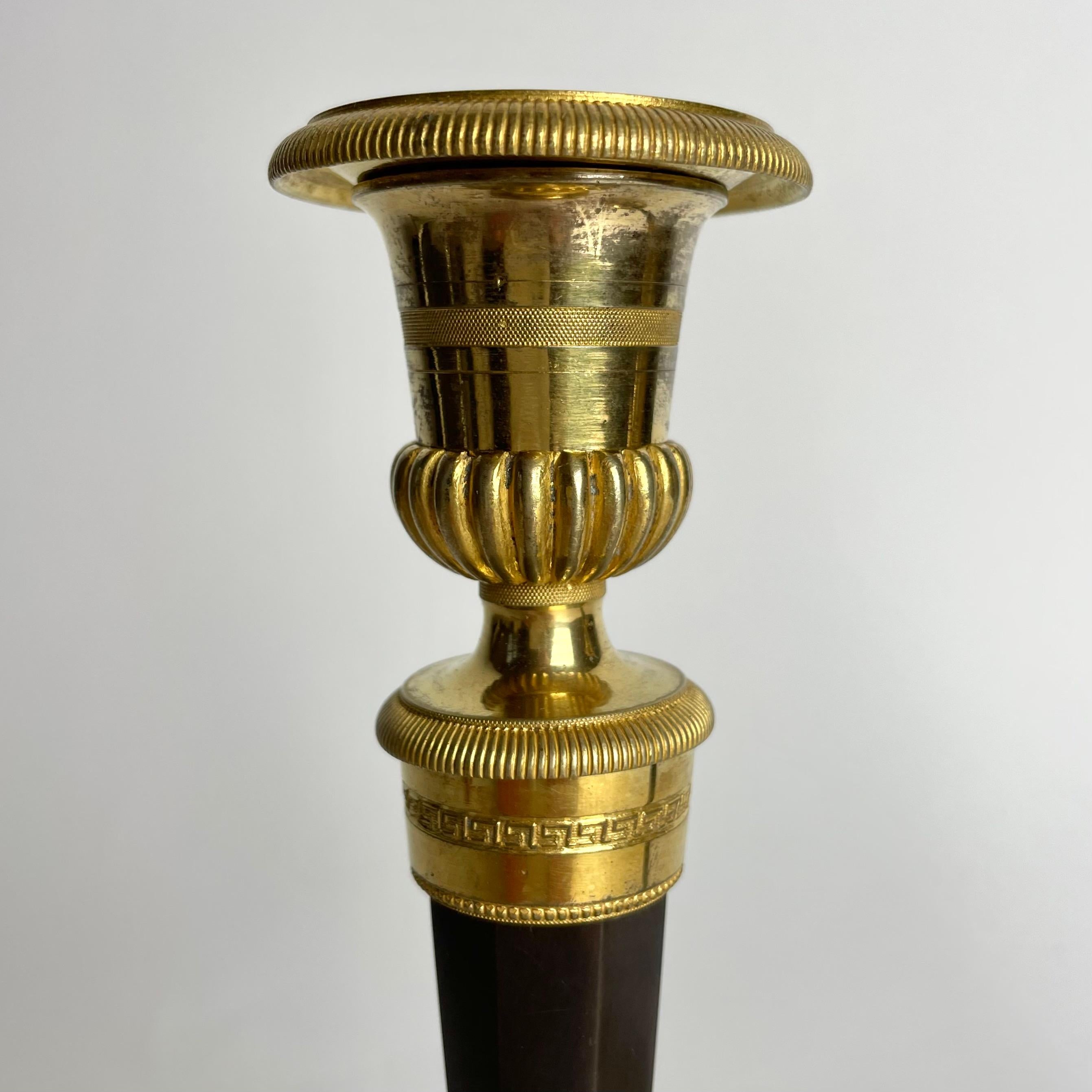 Late 18th Century Pair of Candlesticks in gilded and darkpatinated bronze. Directoire circa 1795 For Sale