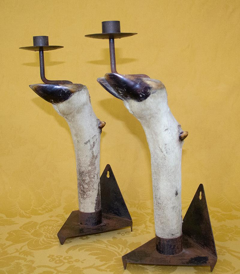 Paar Kerzenhalter aus Stahl, montiert mit Antilopenfüßen. Quadratischer Sockel aus Stahlblech, der umgefaltet wird, um die Beine und die Stütze zu bilden.
