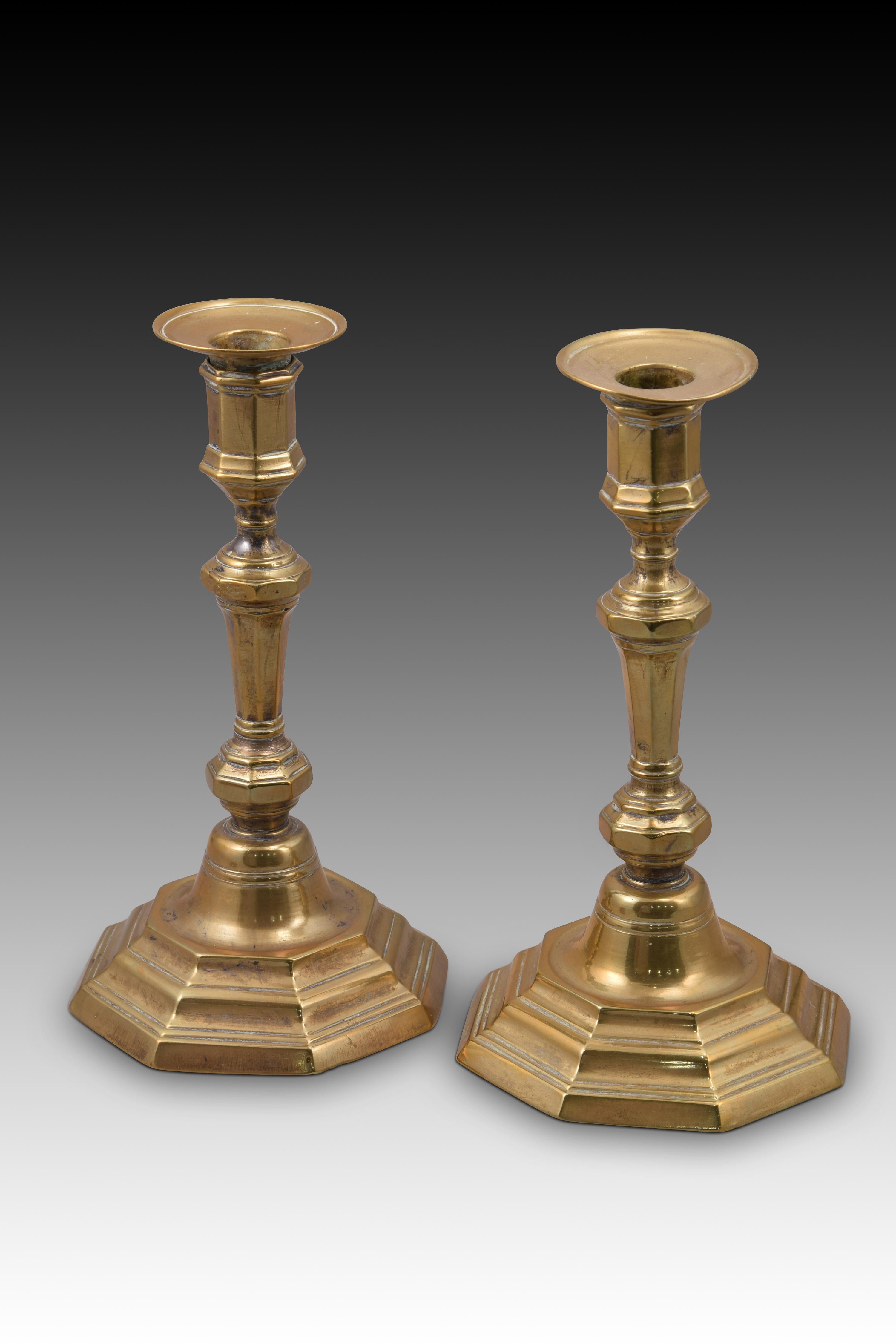 Pair of candlesticks. Bronze. France, 18th century. 
Pair of candlesticks made of bronze that have a polygonal base, stepped upwards and towards the center and enhanced with smooth moldings, a balustraded axis (also with a polygonal section), and an