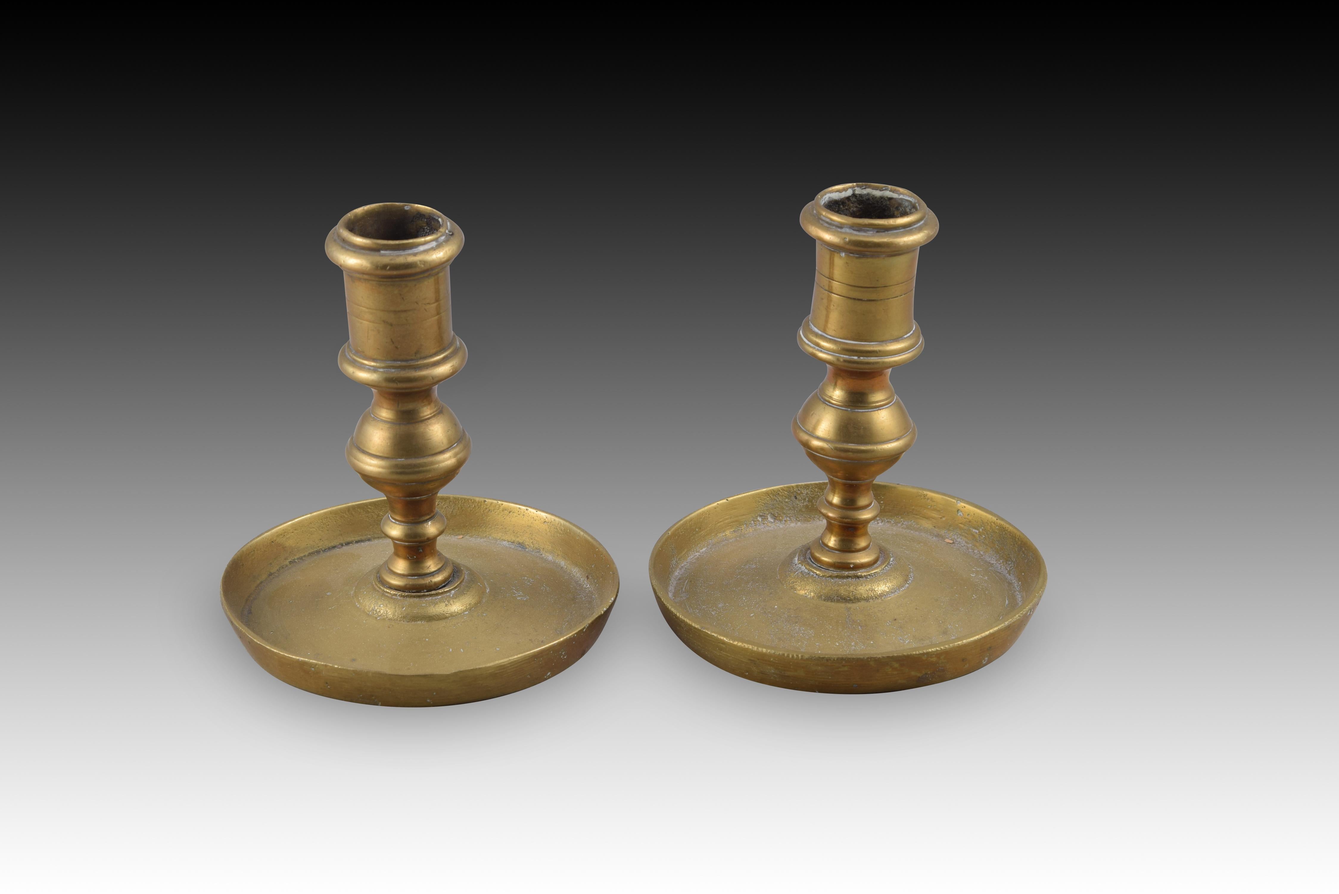 Pair of candlesticks. Bronze. 19th century.
 Pair of bronze candlesticks that have a circular base with a raised edge, a spherical-shaped axis in the center and several moldings of different sizes and tubular lighters raised above and below. This
