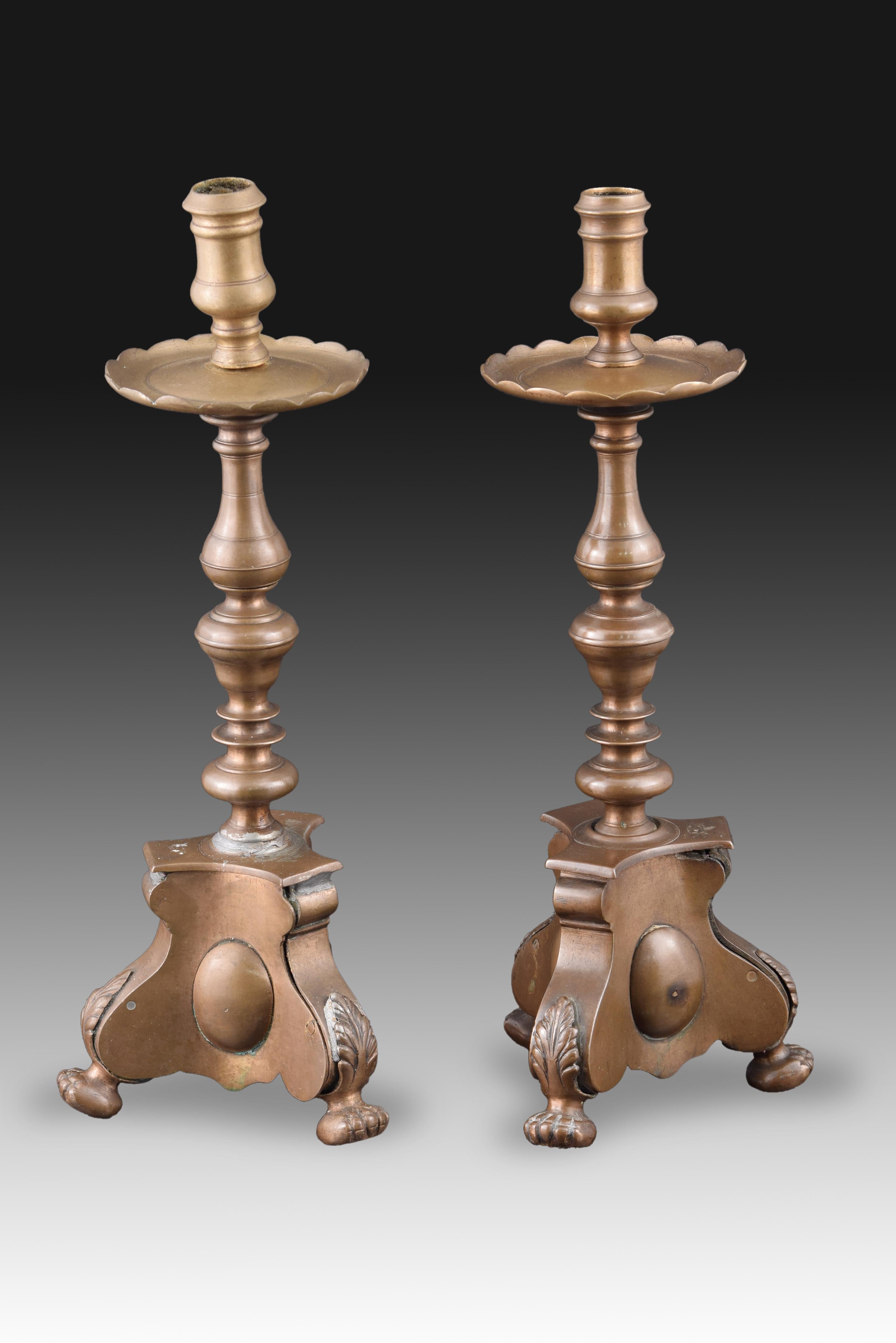 Paar Kerzenständer. Bronze, 18. Jahrhundert.
Ein Paar bronzener Leuchter, die einen starken Einfluss des spanischen Barocks beibehalten, besonders in der gedrehten Achse, mit hervorstehenden Sockeln und kugelförmigen Beinen, die an Tierkrallen