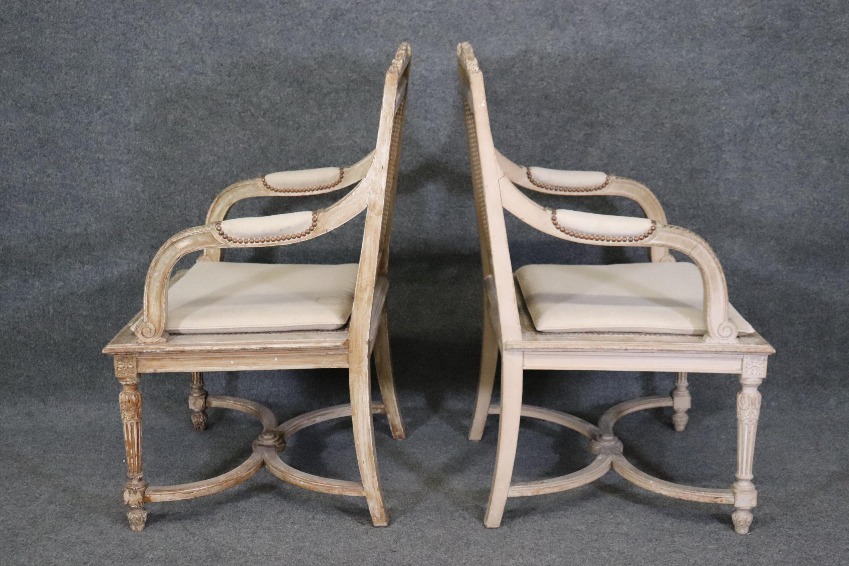 Milieu du XXe siècle   Paire de fauteuils de style Louis XVI à dossier canné peint en blanc antique en vente