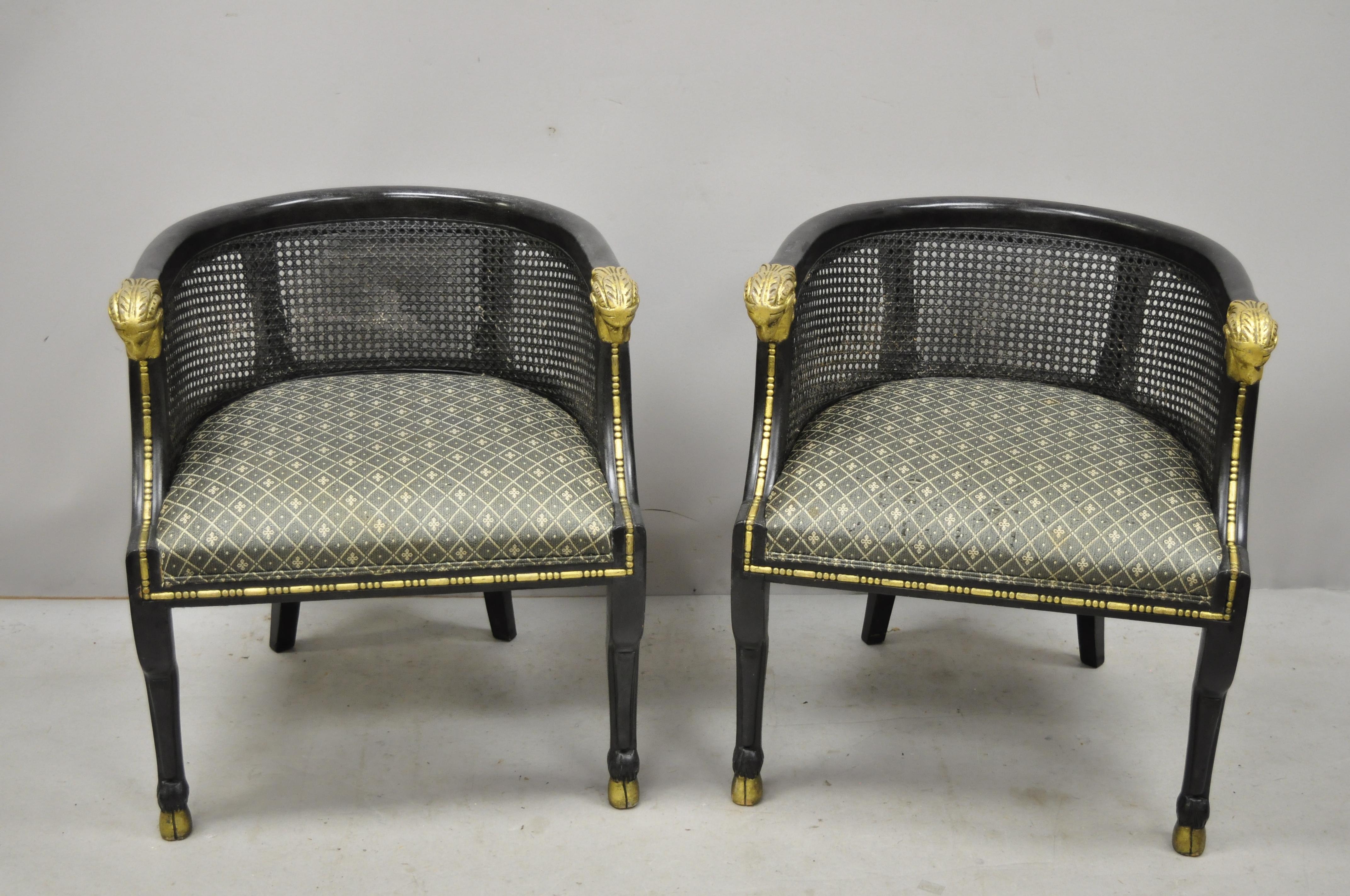 Pair of Cane Barrel back ram's head black and gold club lounge chairs. Item features cane barrel backs, ram's head armrests, hoof feet, nice low profile, solid wood frame, distressed finish, great style and form, circa mid-20th century.
