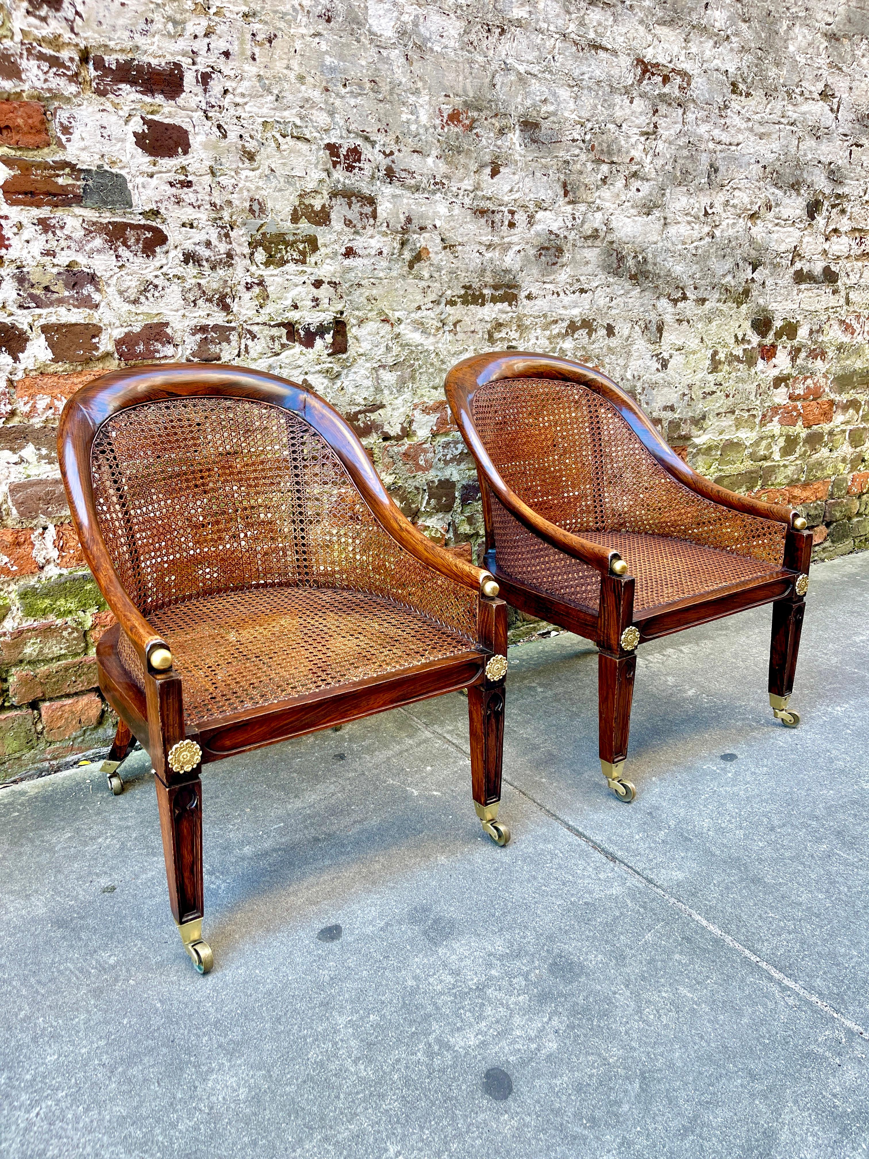 Pair of cane chairs on brass casters. Faux rosewood grain with gold gilt accents. Low size allows window or flanking fireplace placement. 