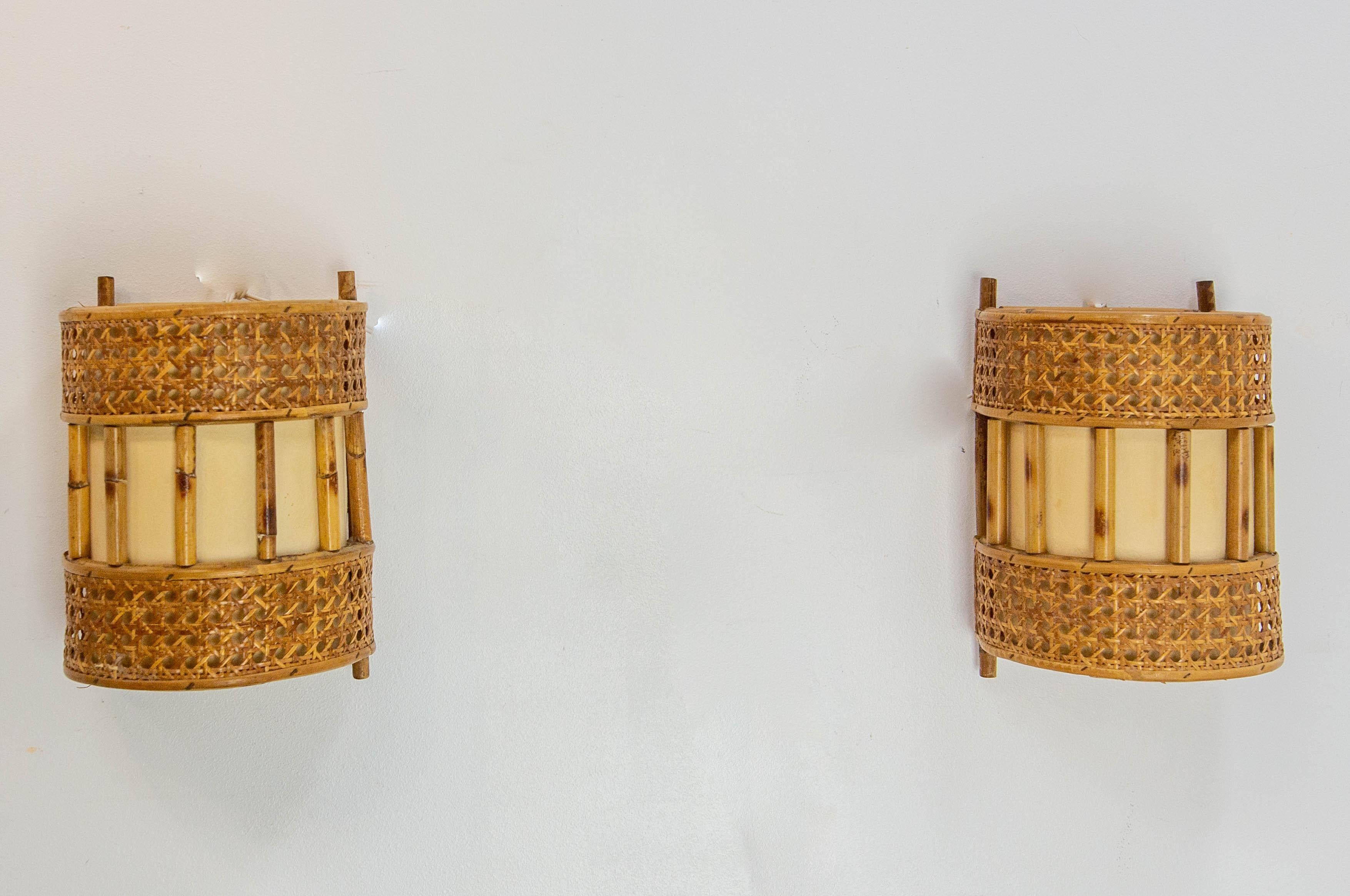 French pair of wall sconces in rattan and fabric.
Wall Lights giving off a lovely warm light.
Louis Sognot has had a long career as a designer. In the 1950s and 1960s, he concentrated on natural materials as rattan and he worked with rounded shapes.