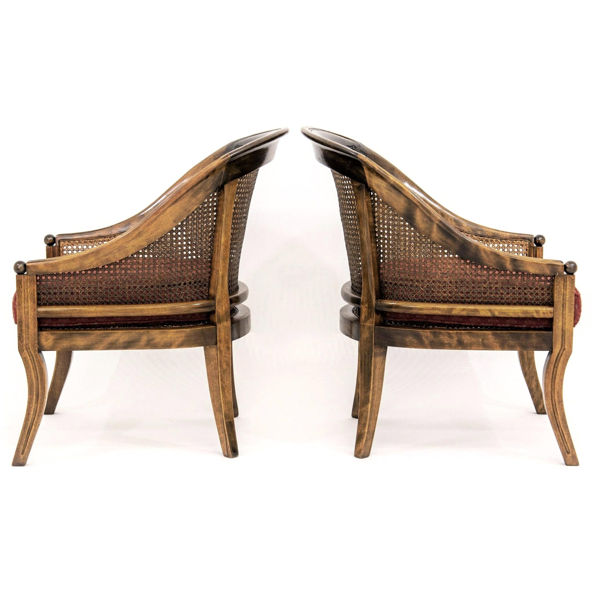 Pair of mid-20th century French Regency style swoop-arm spoon-back library chairs with caned backs, sides and seats raised on sabre legs. The frames are hand-stained with highly contrasting faux-graining lending an exotic and aged appearance. Each