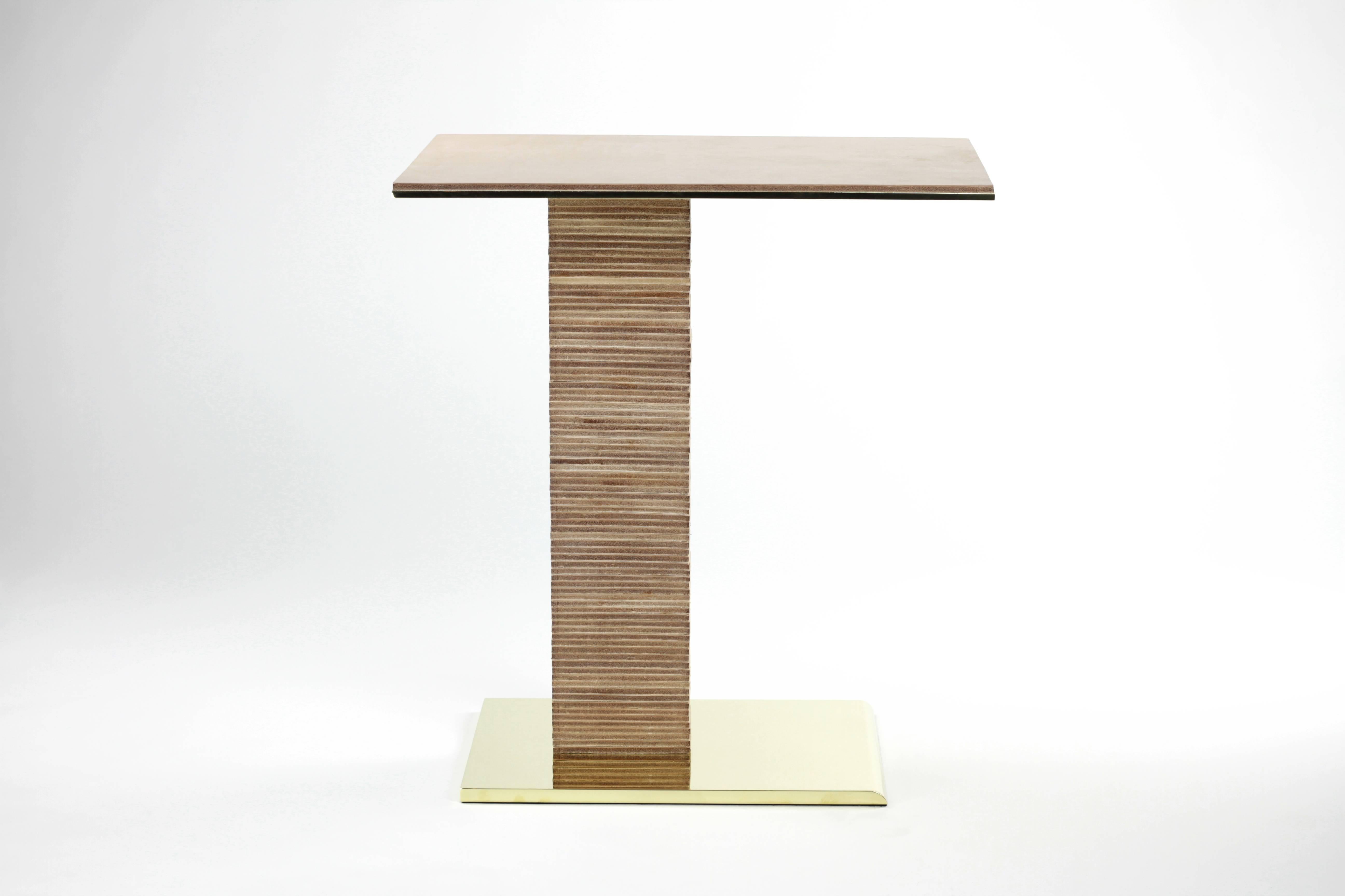 The cantilever infinity side table was inspired by Paul Dupré-Lafon's use of stacked leather in his designs for Hermès. The base is solid brass, beveled at the front, and mirror polished on all sides. Over eighty pieces of leather are stacked to