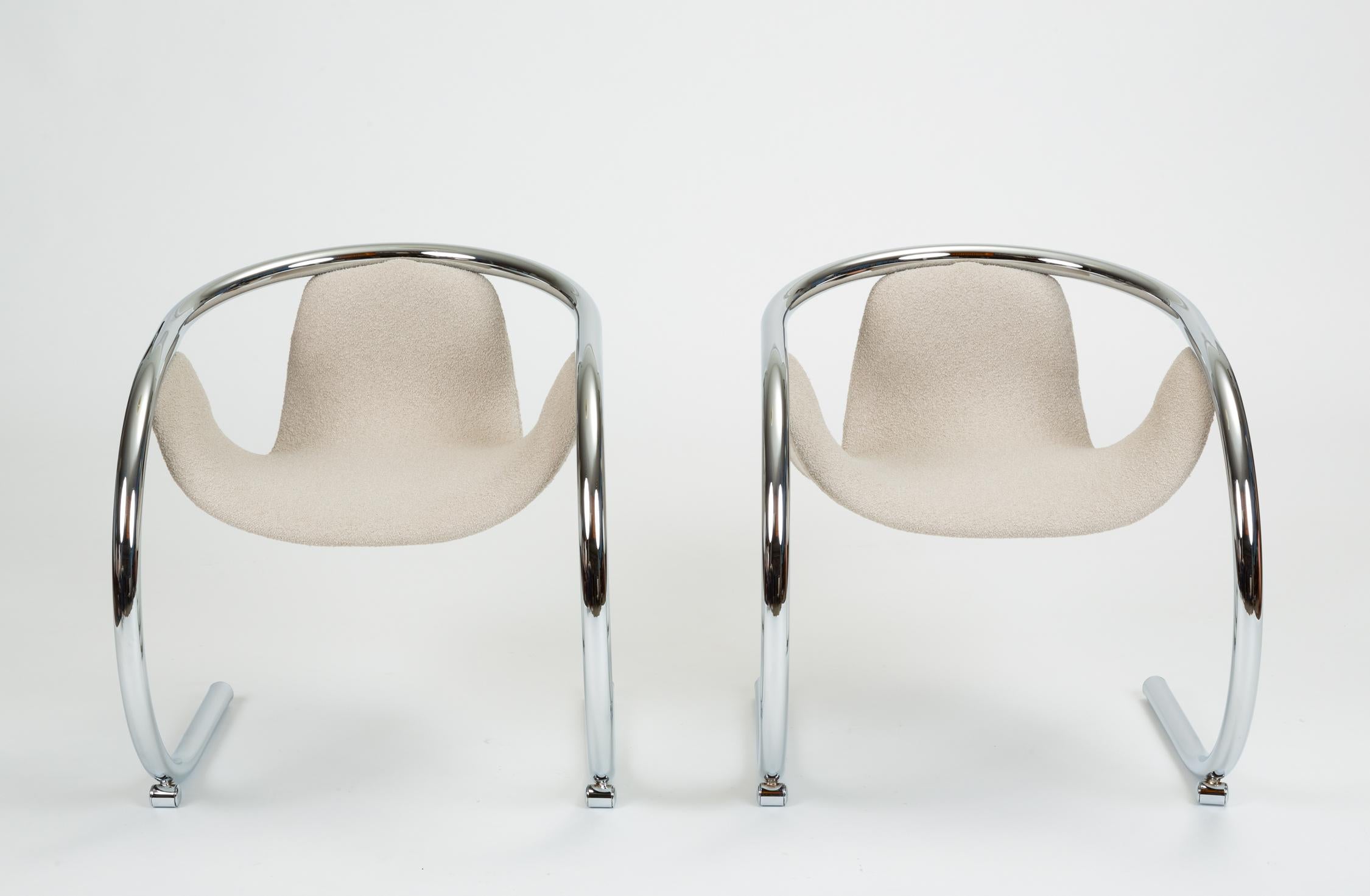 A pair of cantilevered chrome chairs designed by Byron Botker for California-based Landes Manufacturing Co. The sleek design is based around a single, curved frame of wide tubular steel, arched up from the floor to form the chair arms and back.