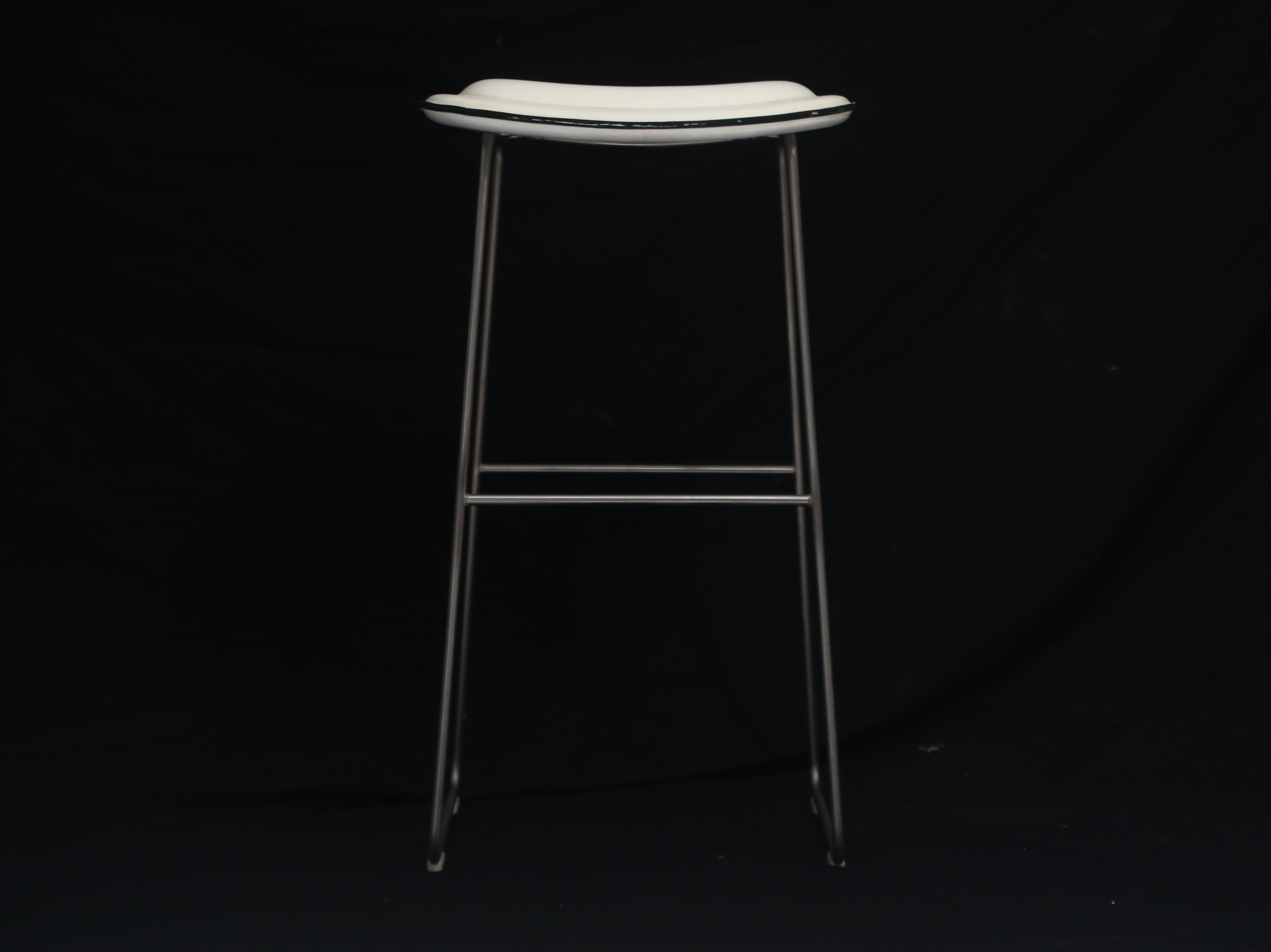 A classy and attractive pair of modern bar height barstools by Cappellini, Italy. This pair of high stools are covered in white faux leather and with a stainless steel base. Cushioned seats make these comfortable for long nights of conversations